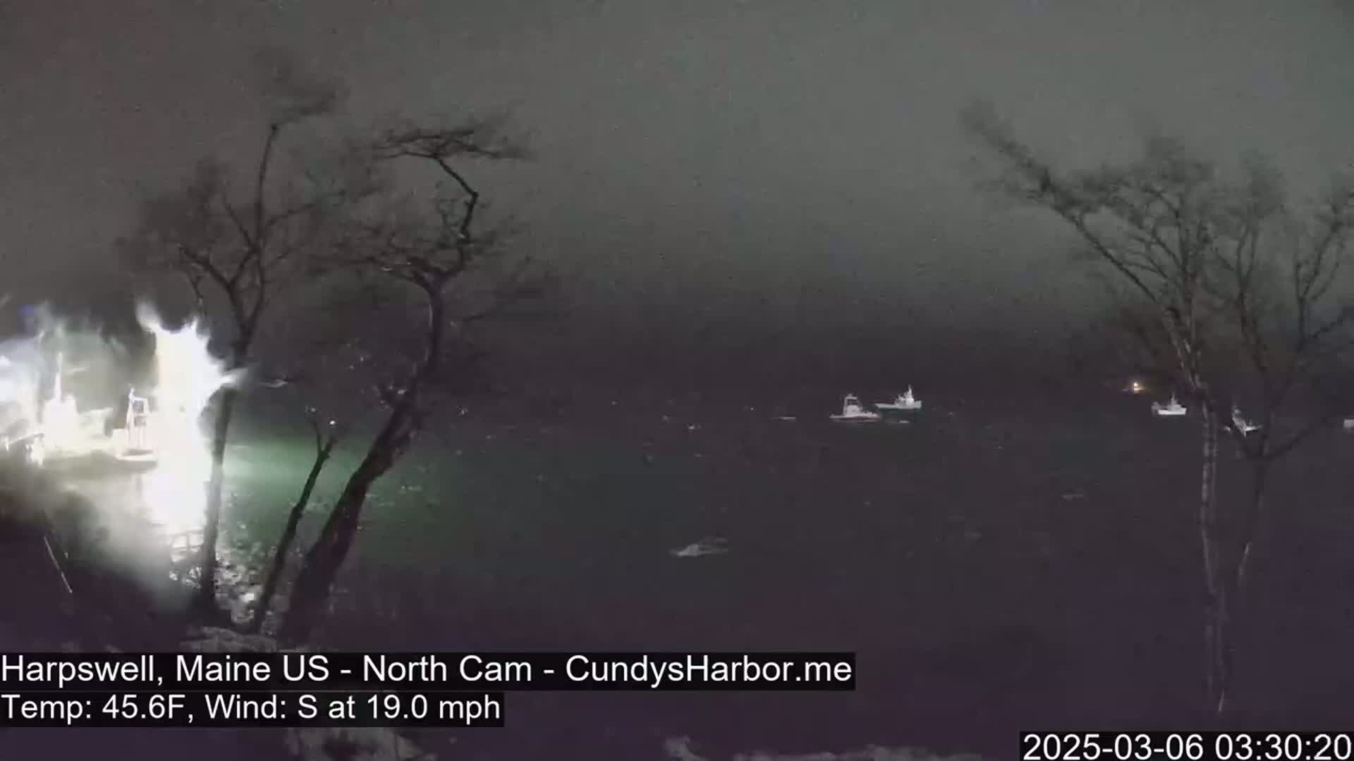 Several boats are visible on a dark, nighttime body of water under a foggy sky with a south wind blowing at 19 mph.