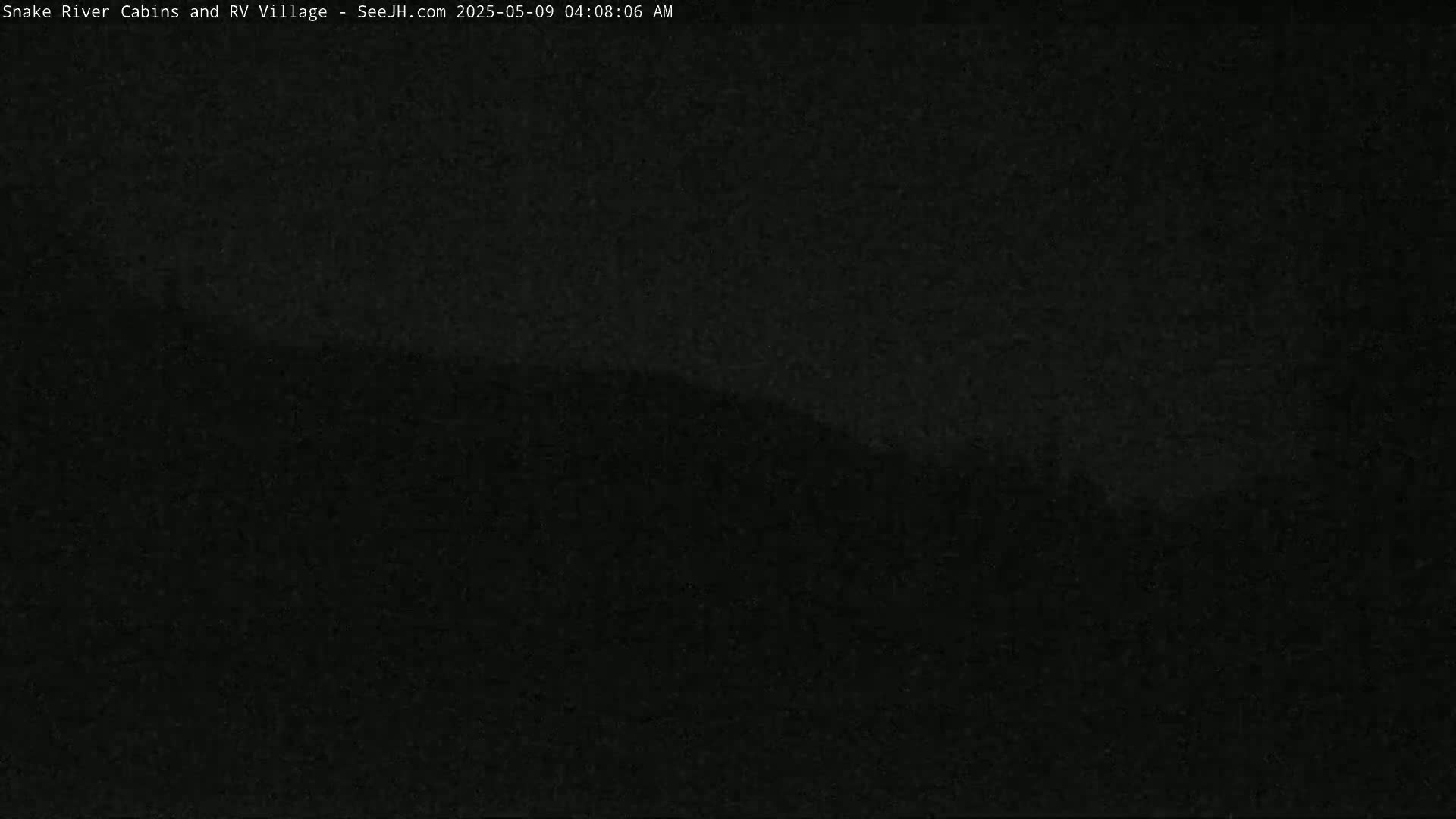 A dark, blurry image shows a mostly black landscape at night.