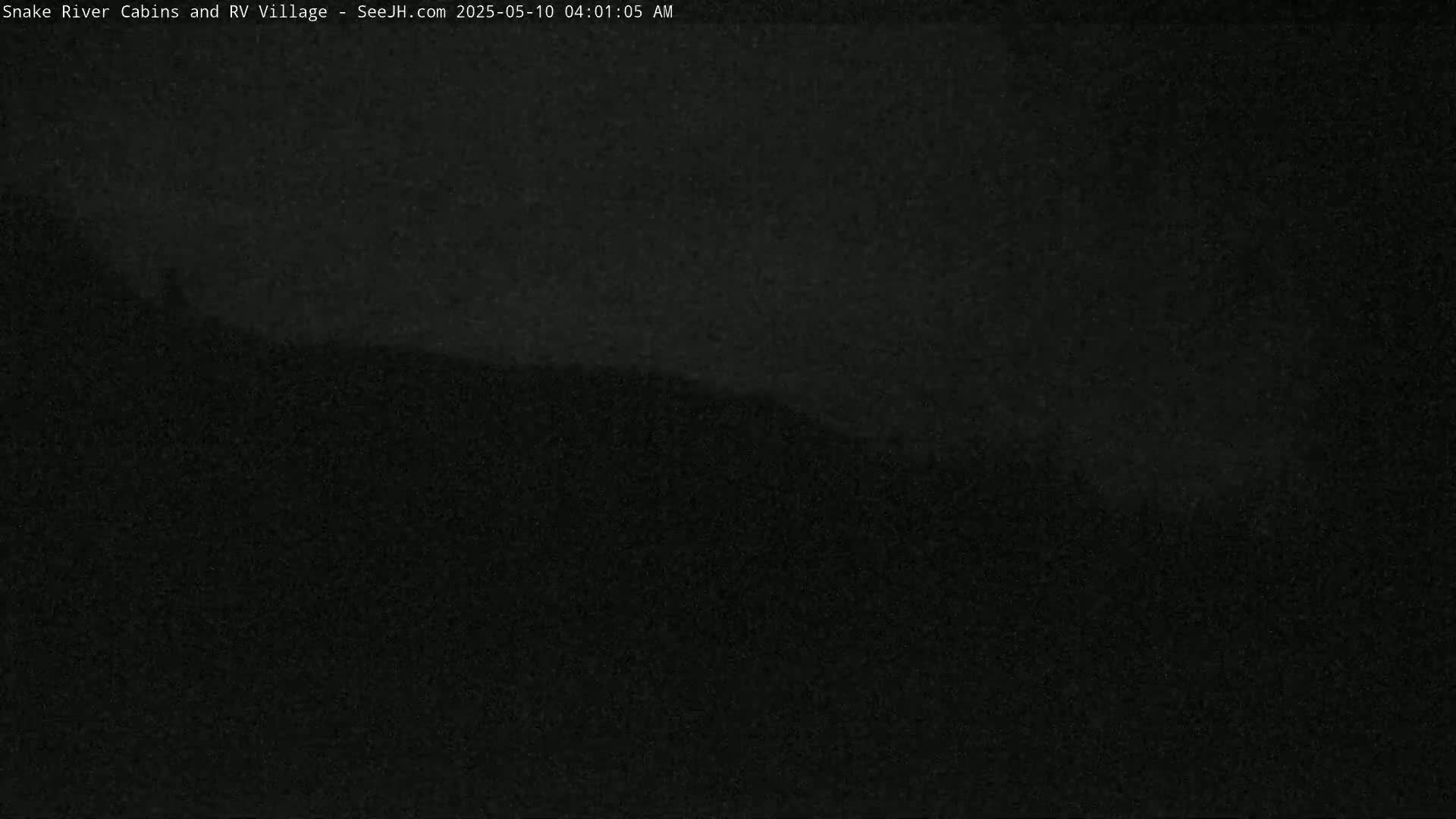 A dark, nighttime image shows a blurry, indistinct landscape.