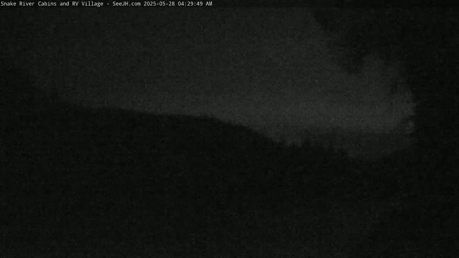 A dark, nighttime image shows a hill silhouetted against a mostly clear, dark sky.