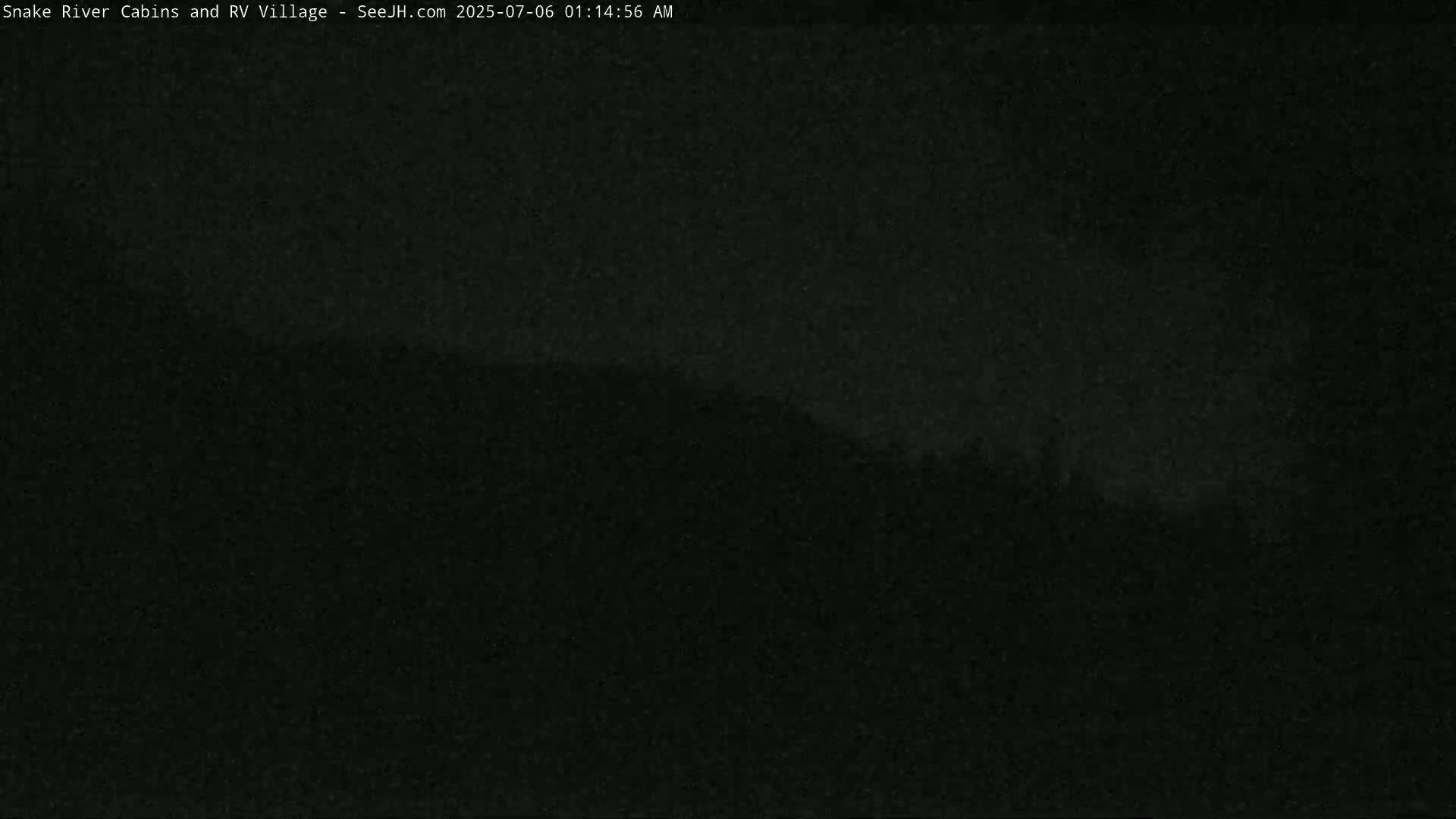 A dark, nighttime image shows a silhouetted hillside in the distance.