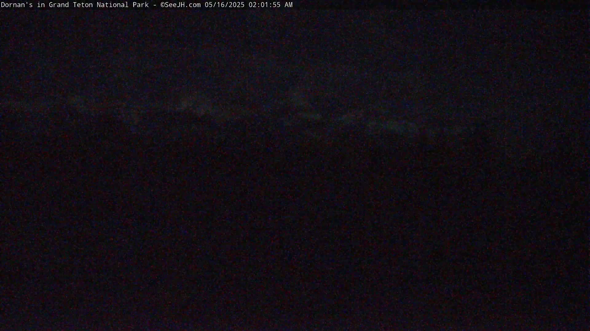 A dark, nighttime scene shows a barely visible, faint horizon line.