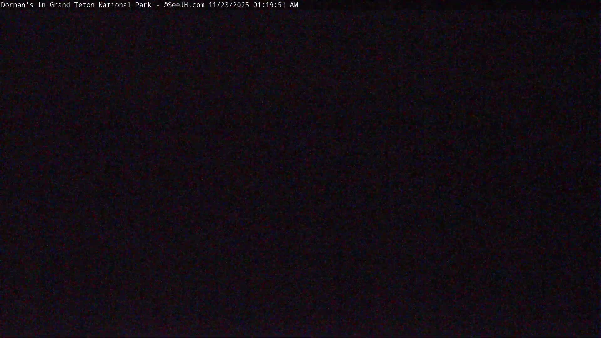 The image is completely black with slight visual noise, showing an outdoor scene at night with no visible features or specific weather conditions discernible.