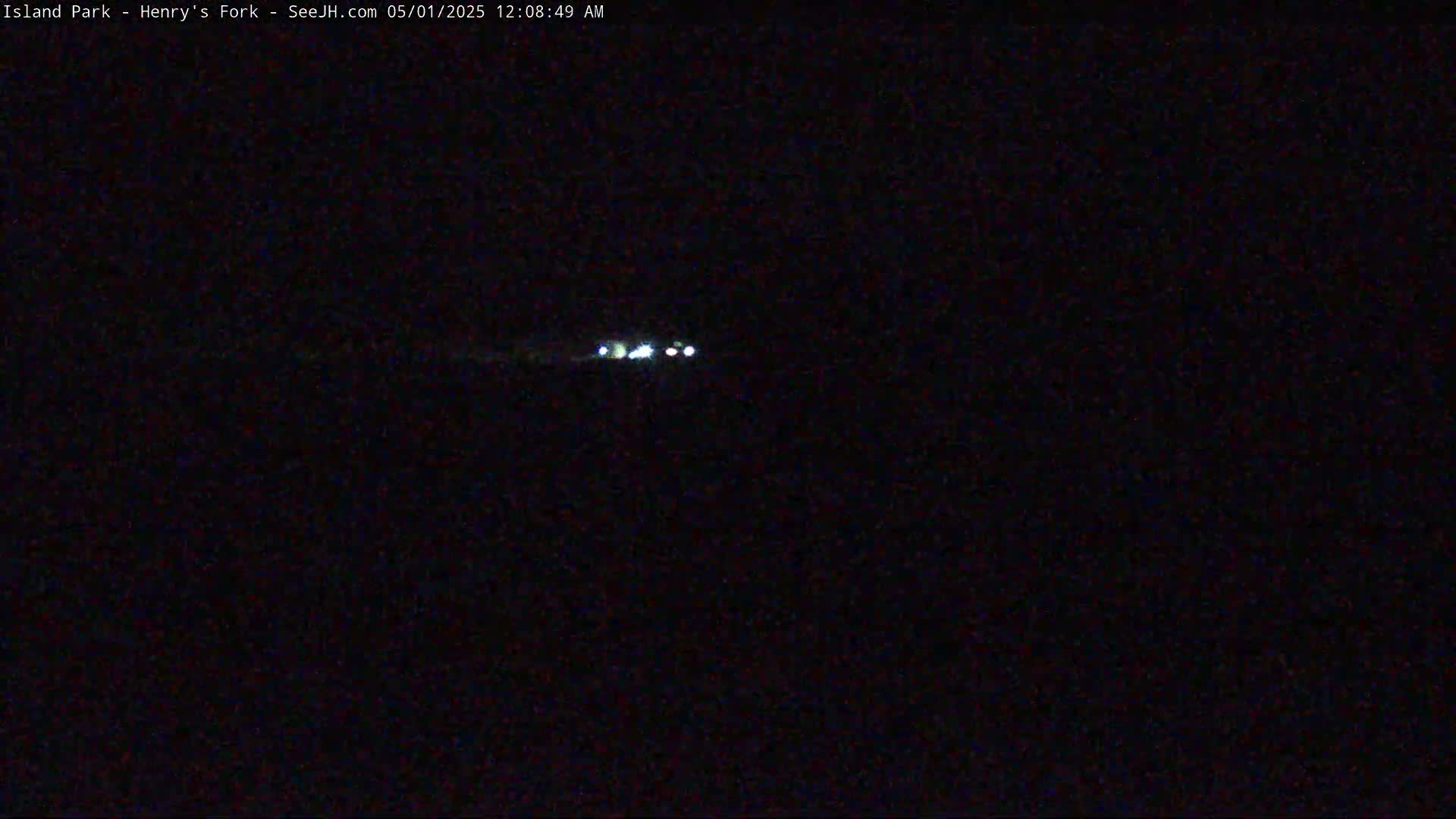 At night, a vehicle's headlights are visible in the distance.