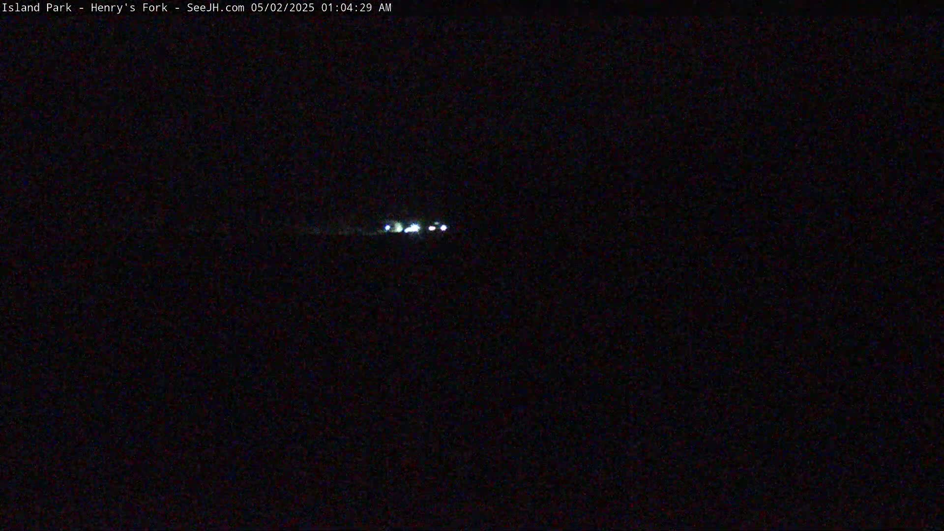 At night, a few vehicle headlights are visible in the far distance.