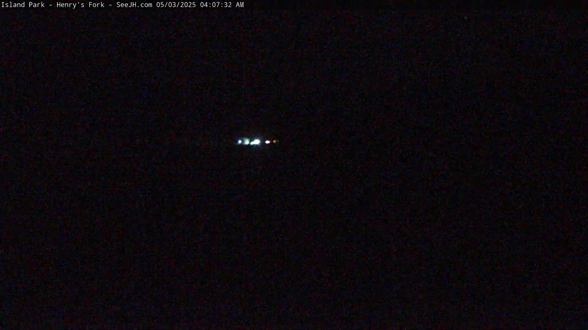 A nighttime long shot shows a few small, distant lights in the dark.