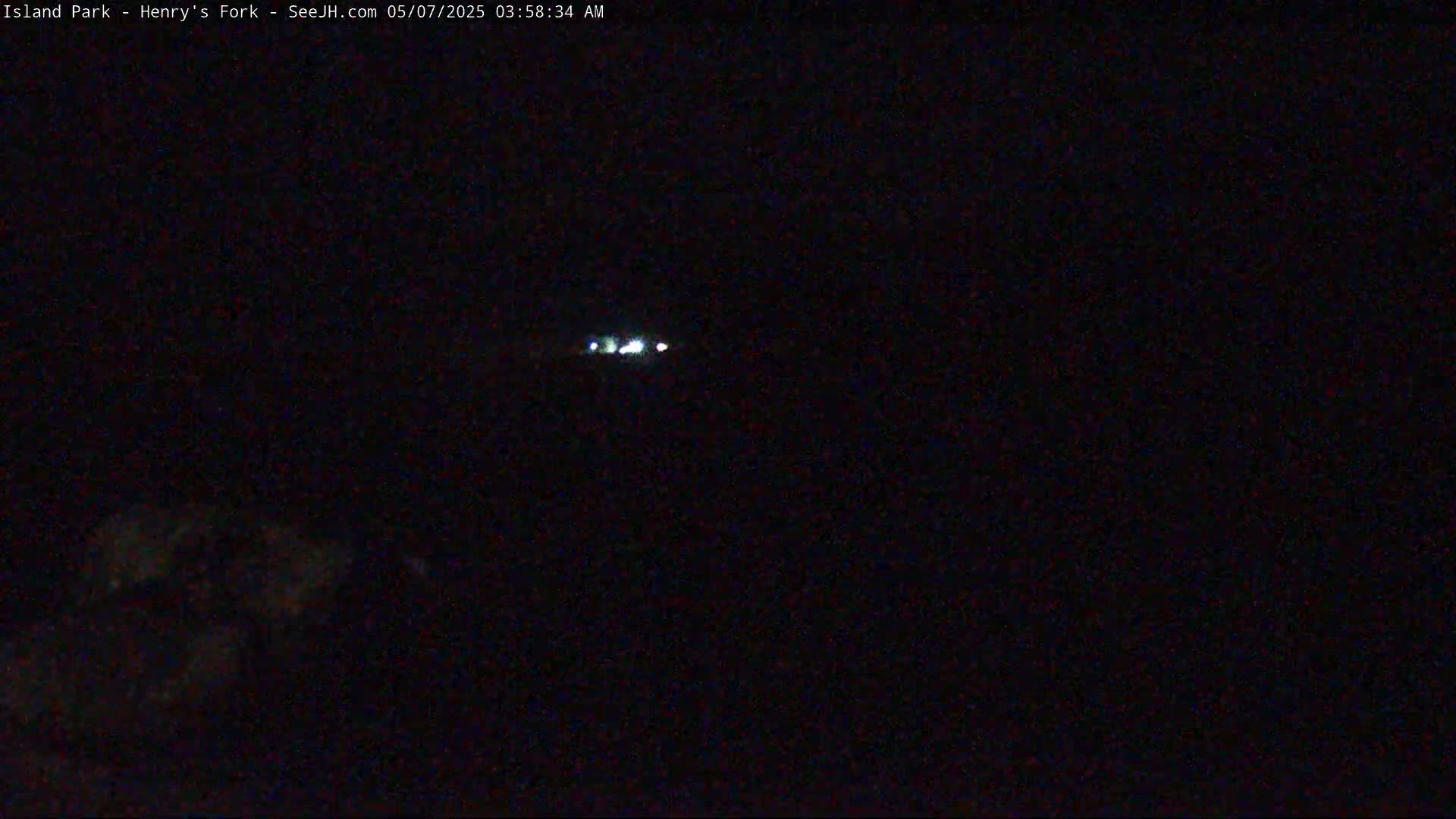 A distant line of faint lights is visible in the dark night sky.