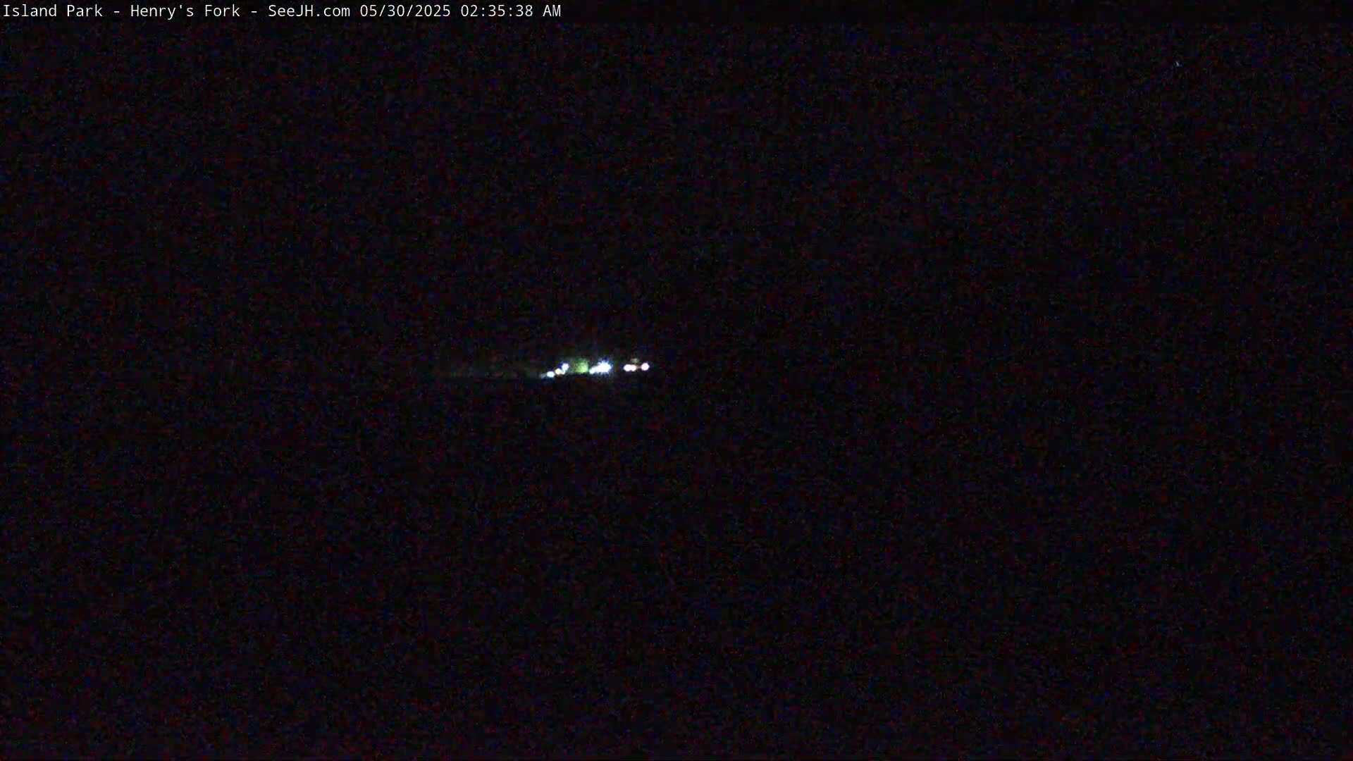 A long distance view of a few small, distant lights at night.