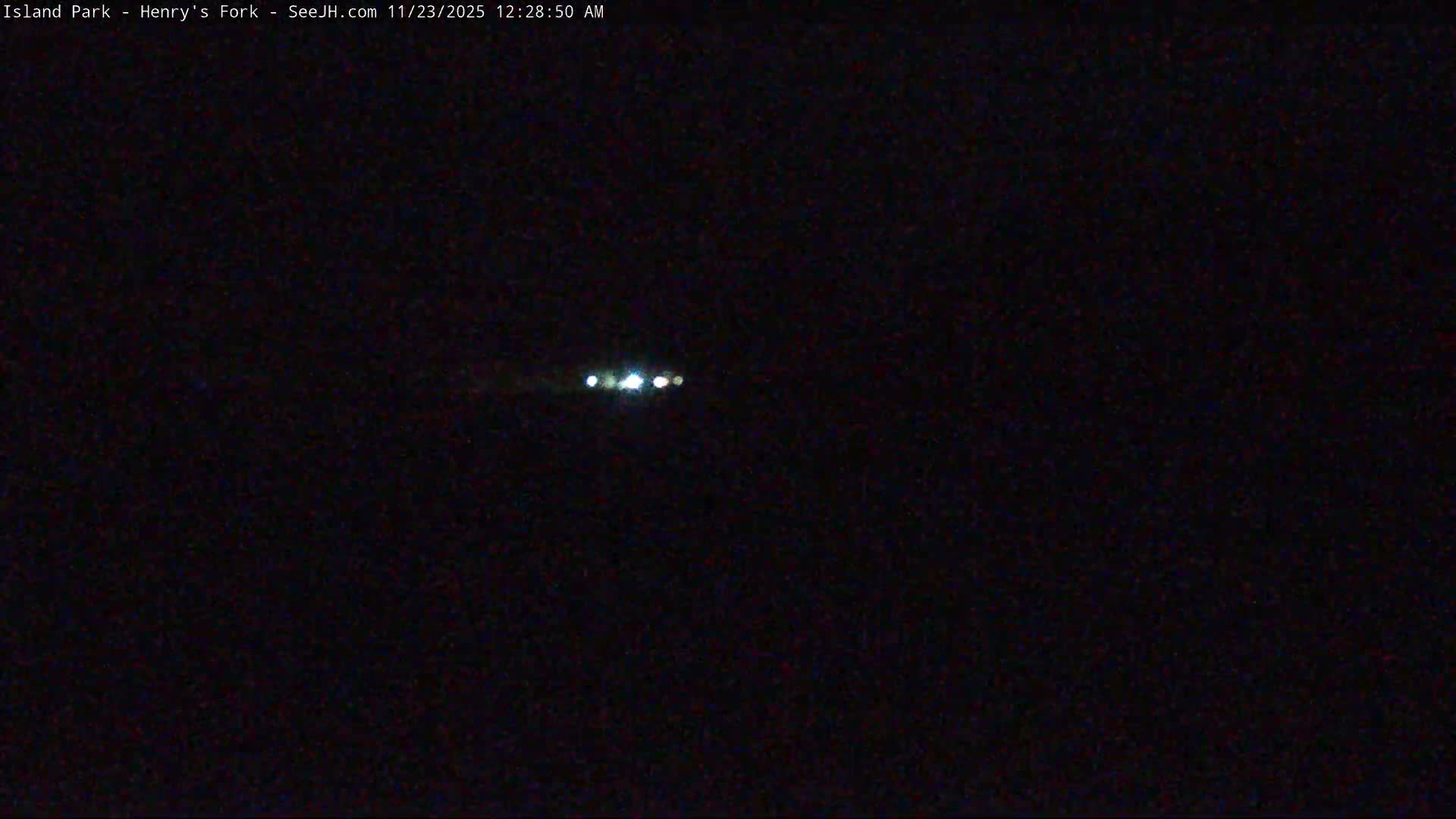 Several bright white lights are visible in the distance against a dark, featureless background on a clear night.