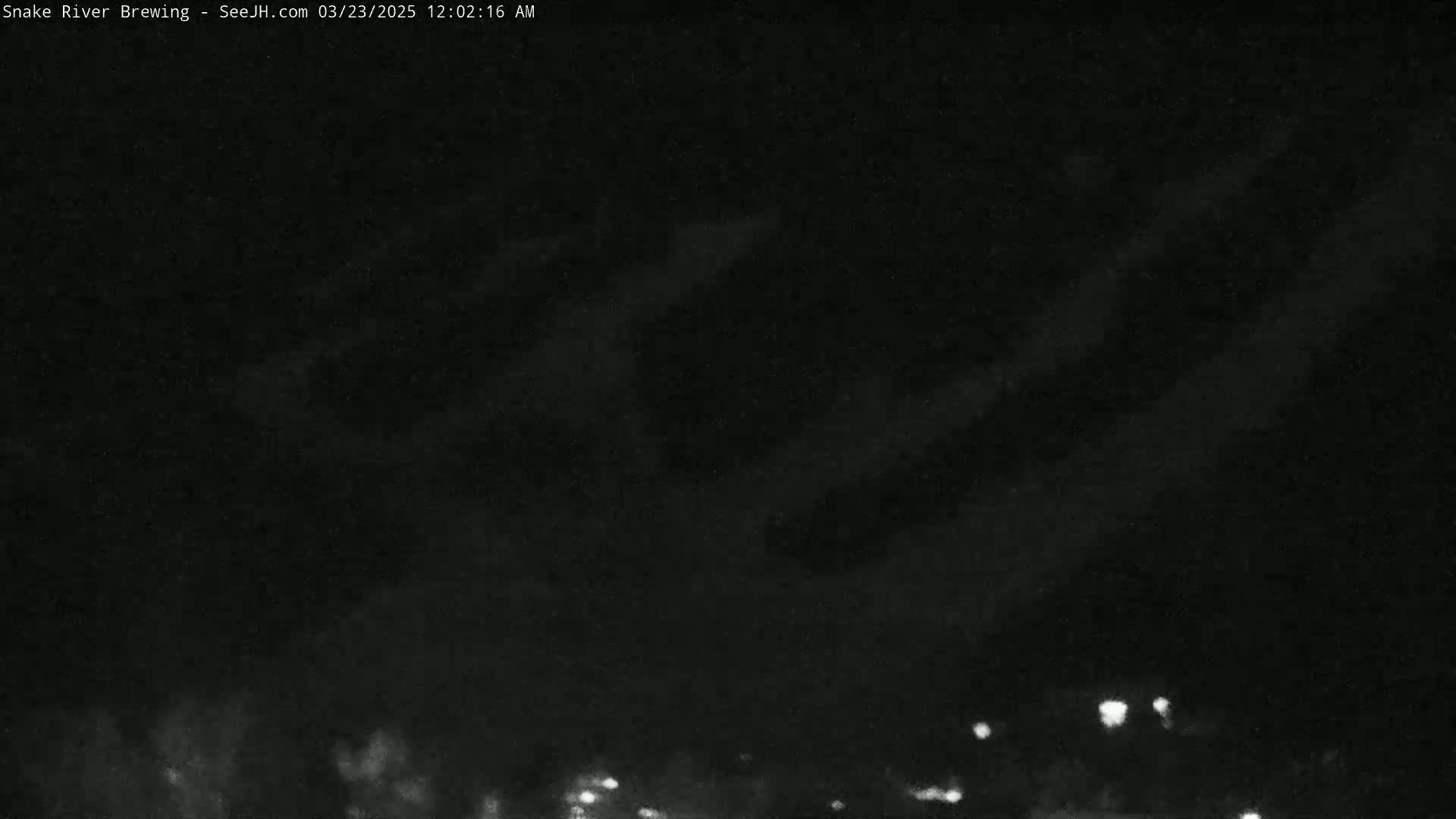 A nighttime outdoor scene shows a dark sky with some faint clouds and a few distant lights visible at the bottom.