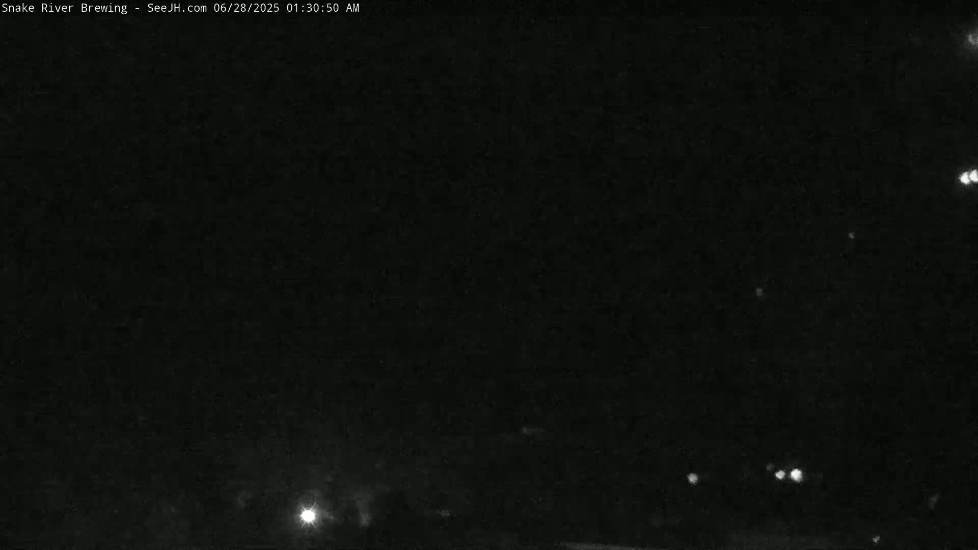 A nighttime outdoor scene shows a dark sky with a few faint lights visible in the distance.