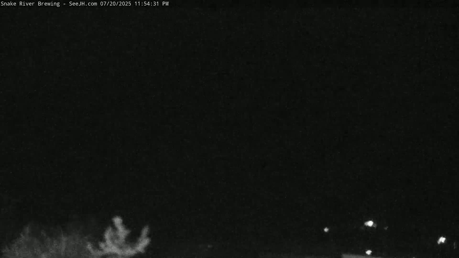 A nighttime outdoor scene shows a mostly dark sky with a few distant lights visible at the bottom of the frame.