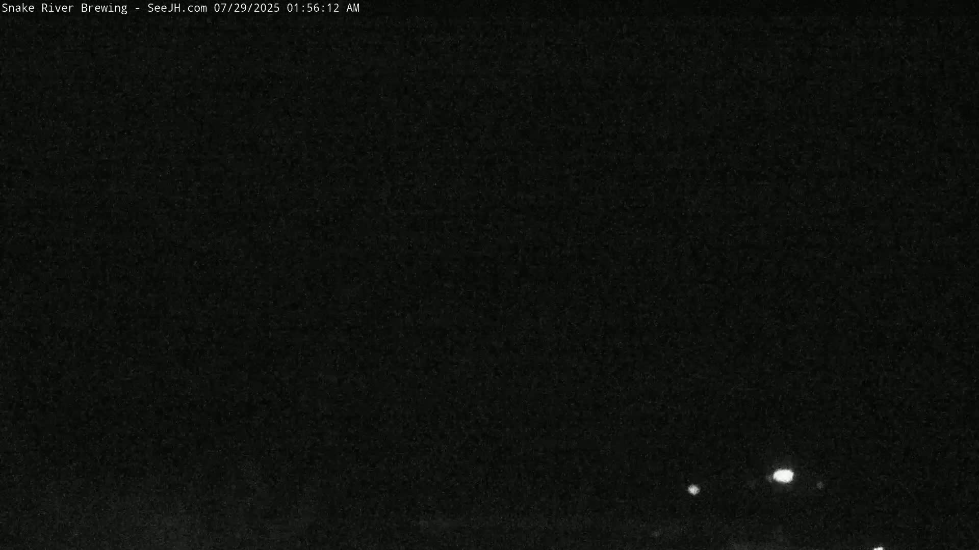 A nighttime outdoor scene shows a very dark sky with a few distant lights visible.