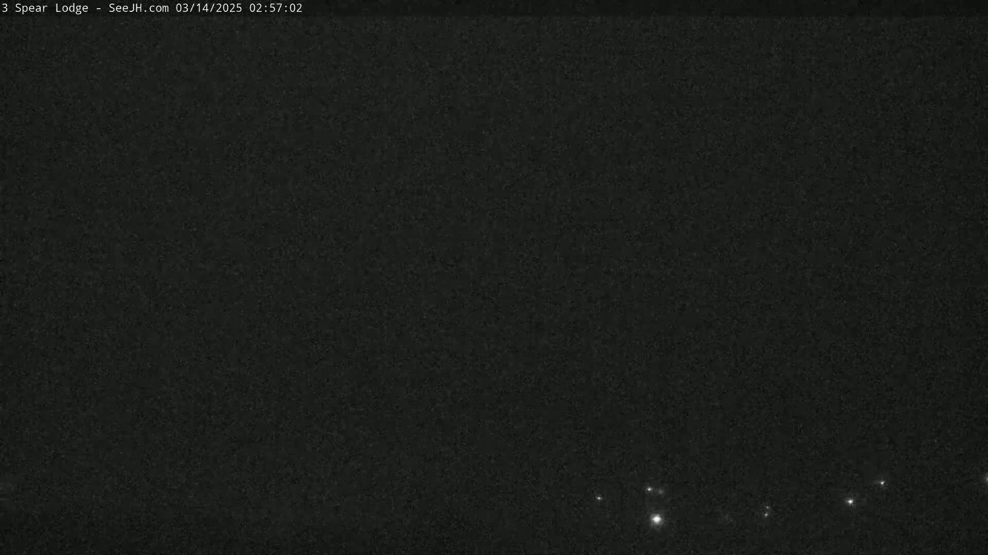 A mostly dark, night sky shows a few small, bright lights near the horizon.