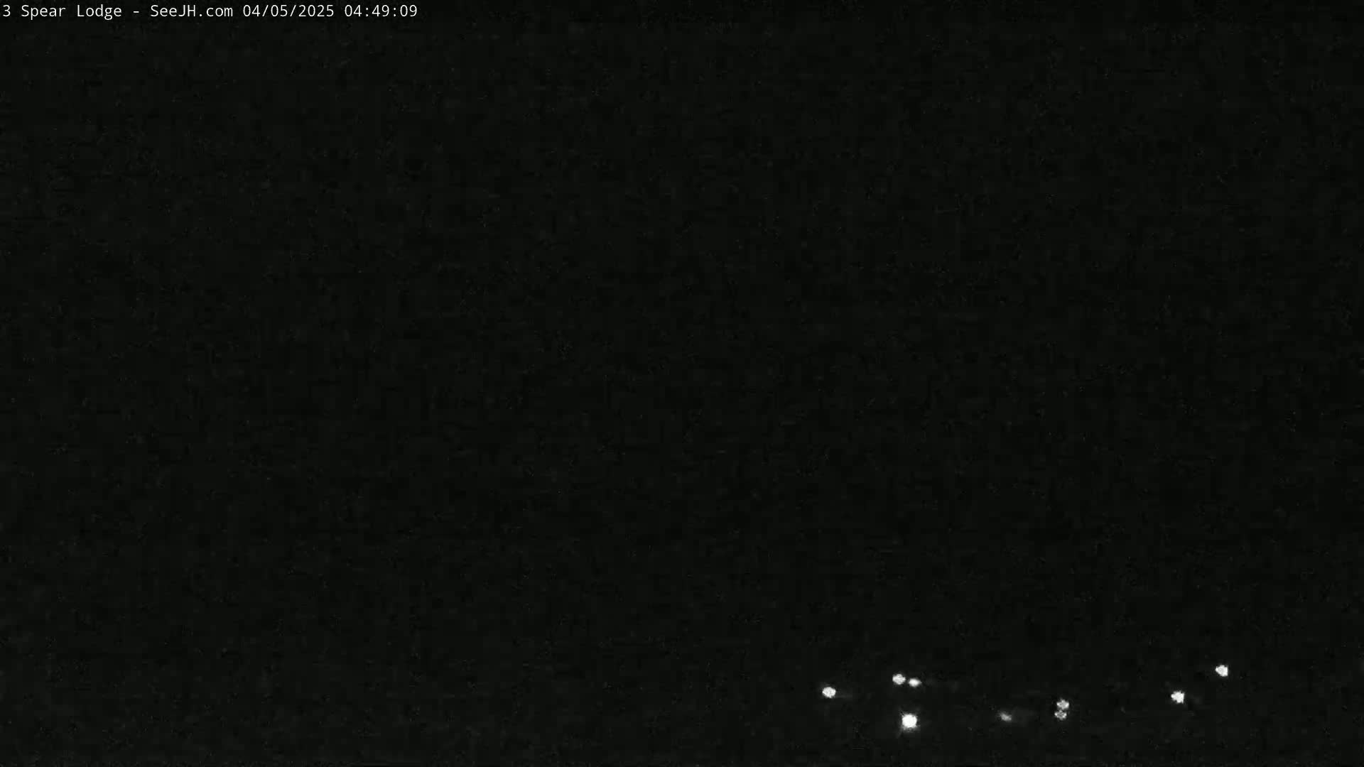 A nighttime, dark image shows a few small, distant lights at the bottom.