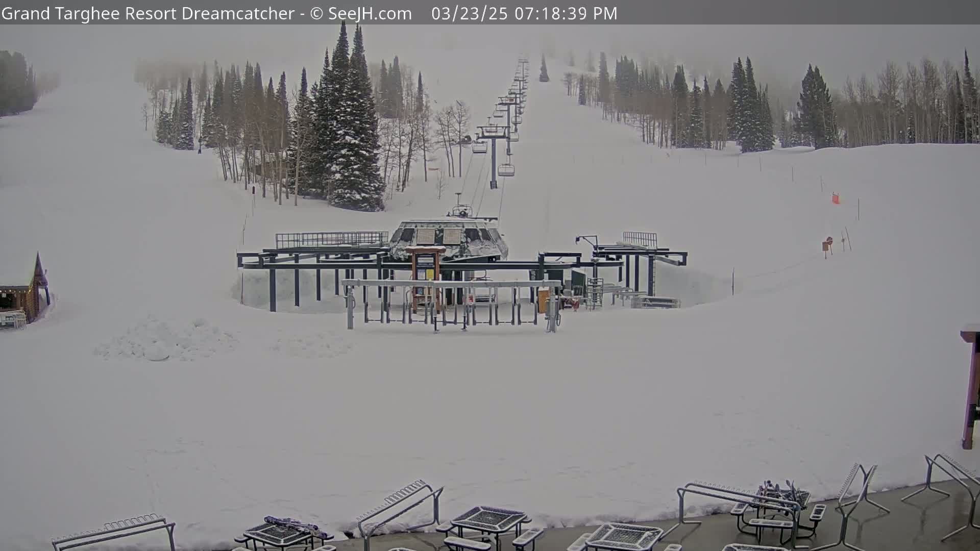 A chairlift at a snow-covered ski resort on an overcast day.