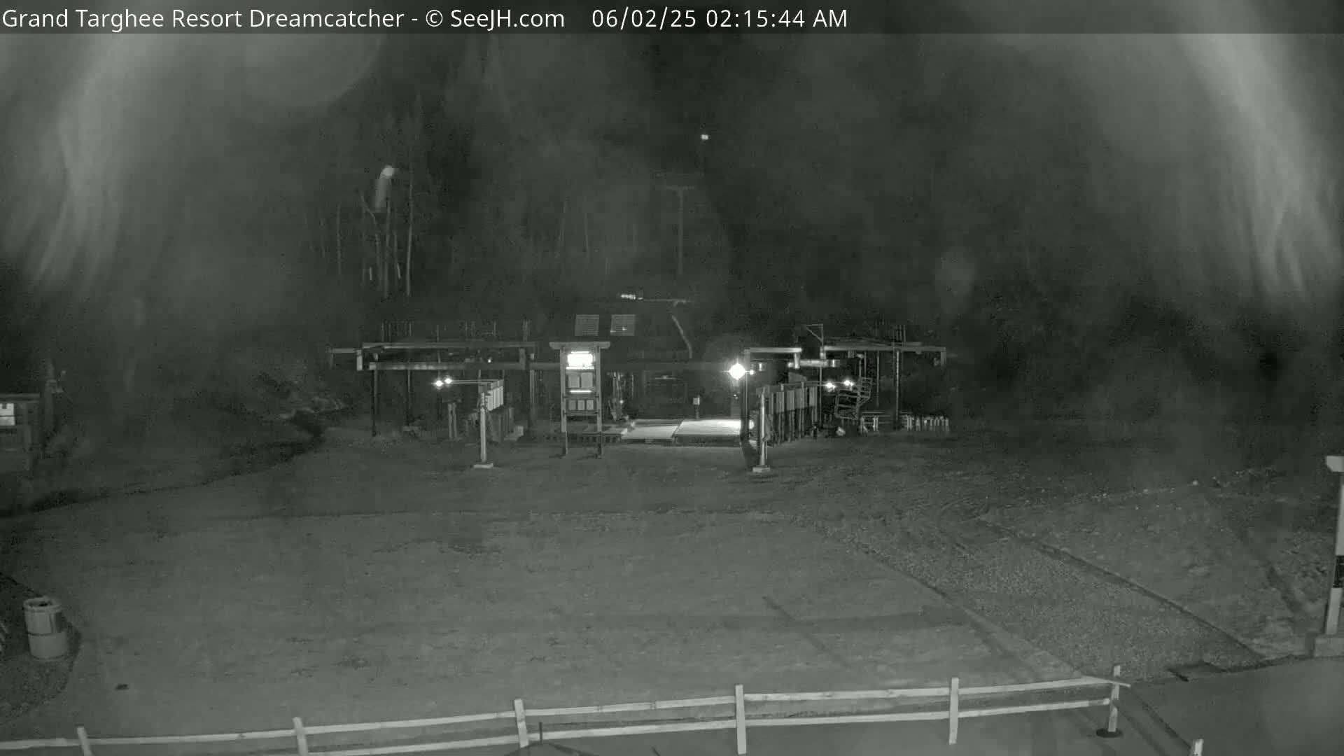 A nighttime, low-visibility view of a building complex, possibly a resort entrance, with hazy or foggy conditions.