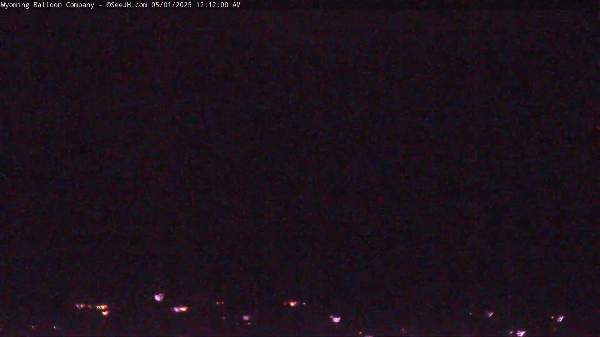A nighttime, low-light view shows a dark sky with a few faint lights visible near the bottom of the frame.