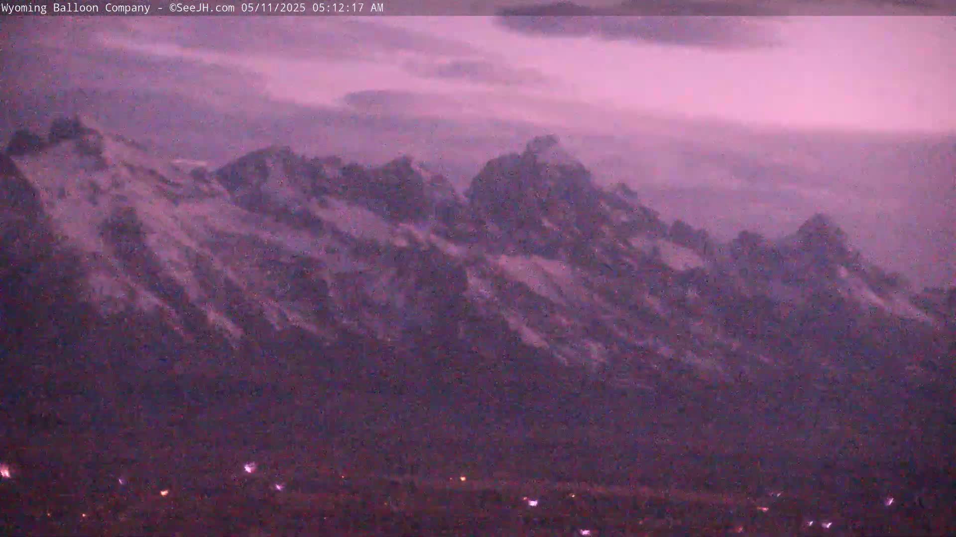 A distant, snow-capped mountain range is visible under a purplish-pink twilight sky.