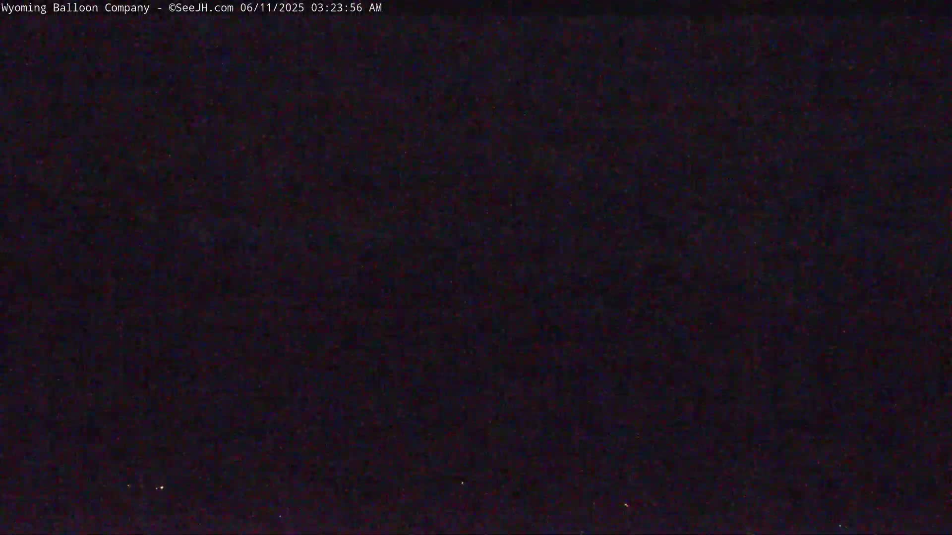 A dark, nighttime scene shows a mostly black sky with a few faint lights.