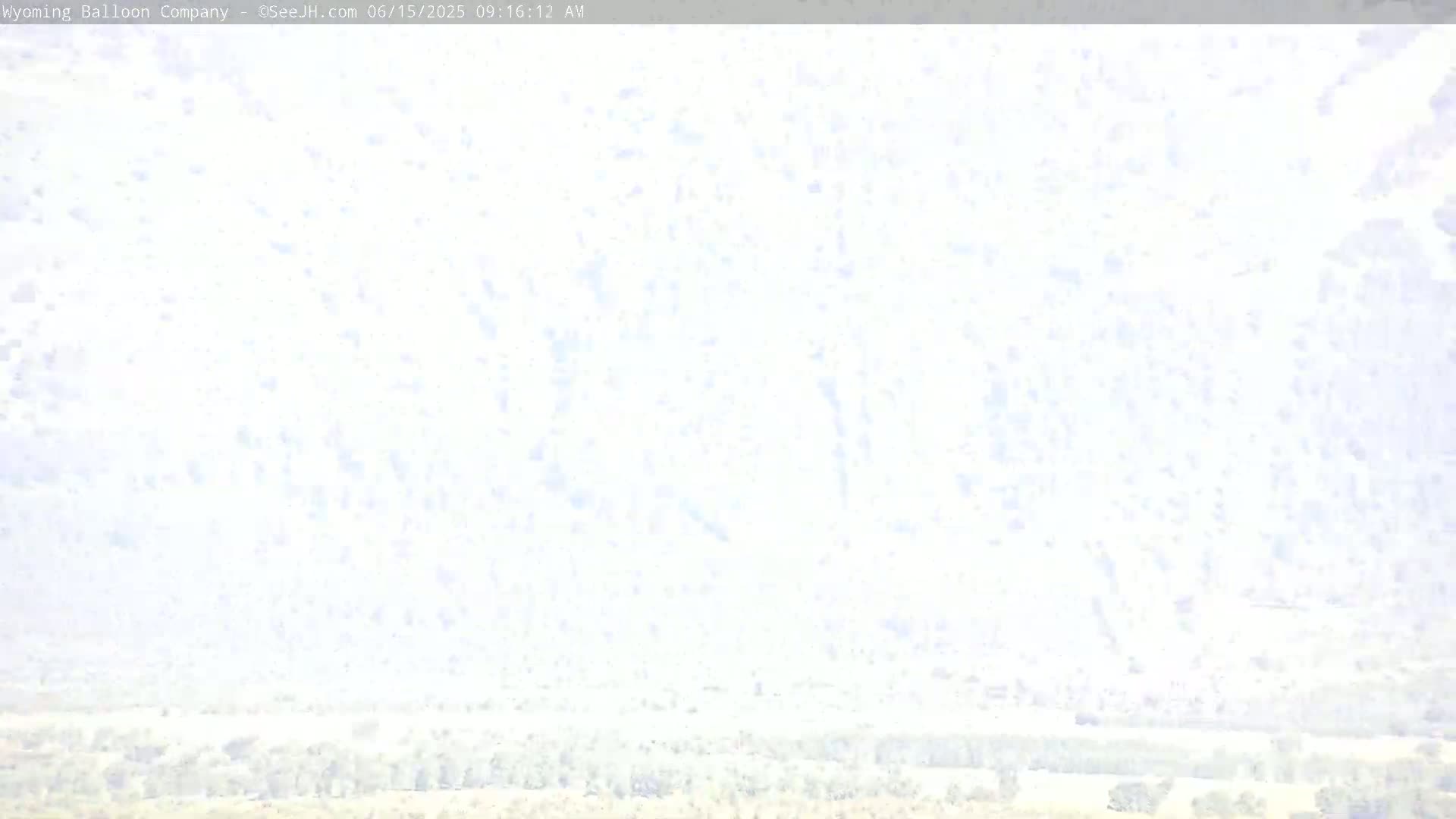 A hazy, bright sky above a flat, light-colored landscape.
