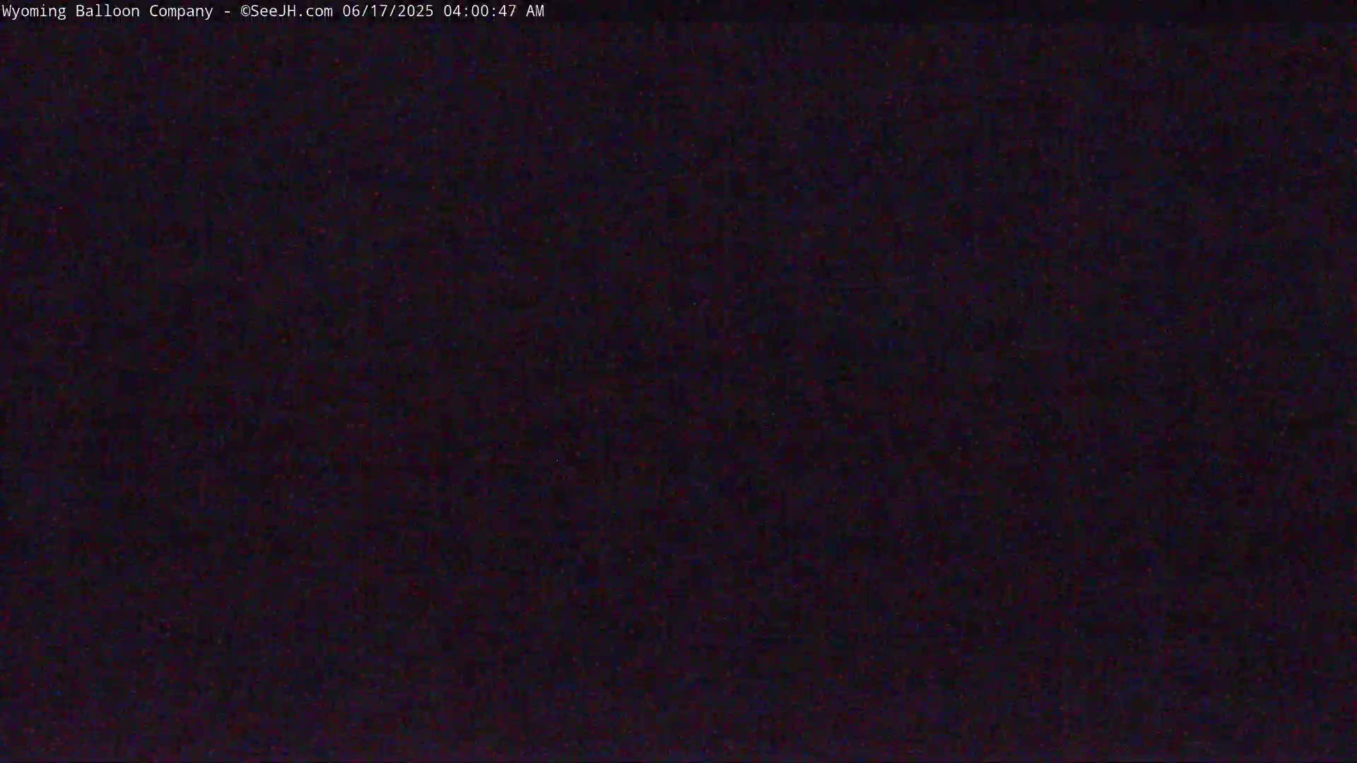 A dark, possibly nighttime image shows a mostly uniform black or dark-purple field with slight textural variation.