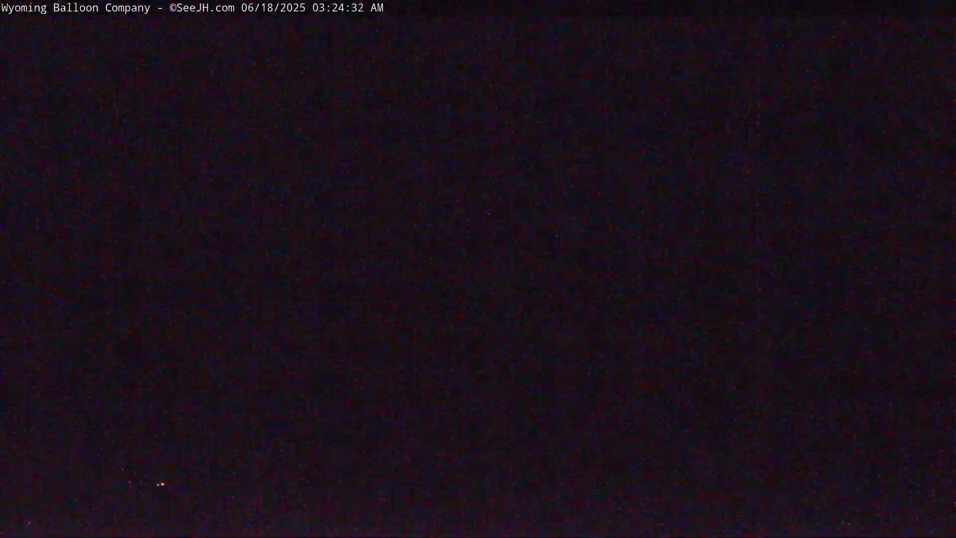 The image shows a dark, nighttime scene with two small, faint lights visible in the lower portion.