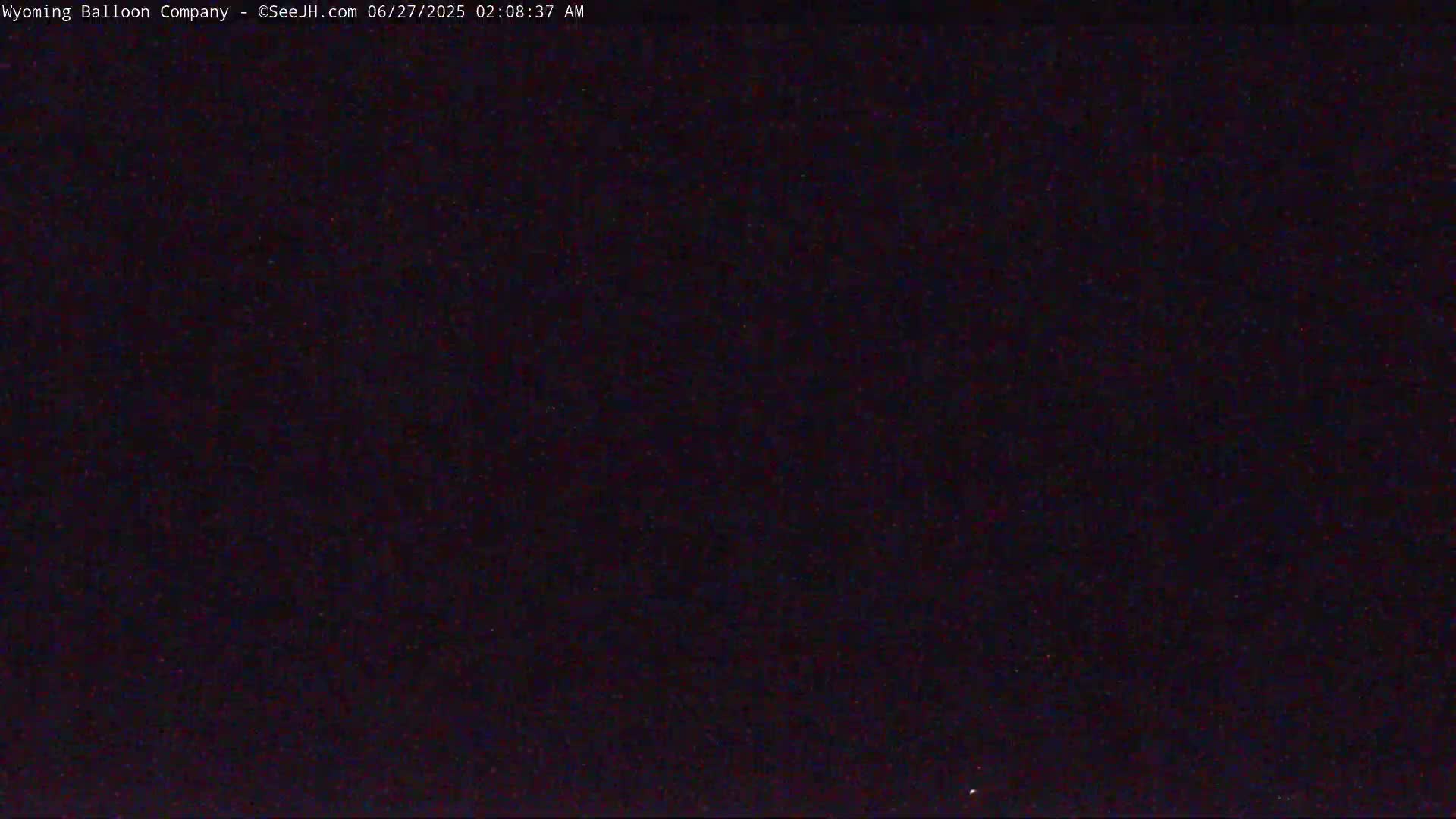 The image shows a dark, nighttime sky with a few barely visible stars.