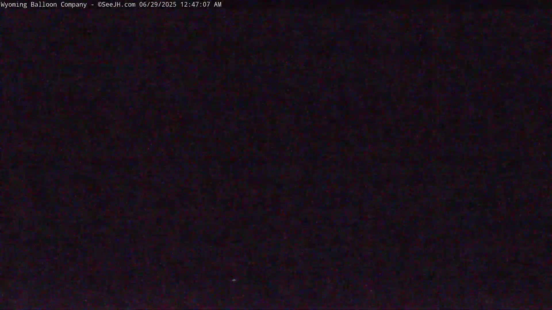 A dark, nighttime image shows a mostly featureless, black sky.