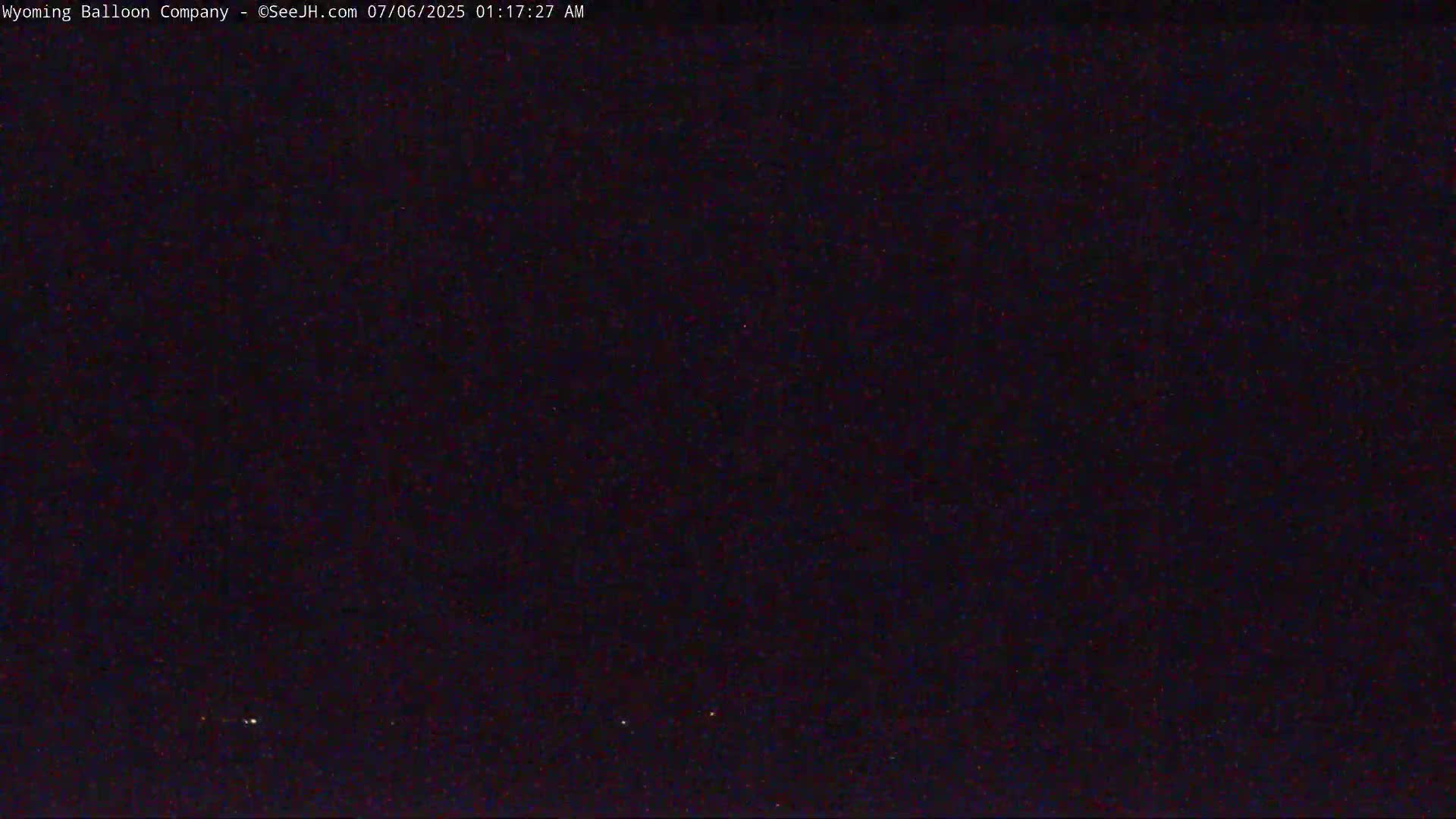 A dark, nighttime sky with a few faint lights visible on the horizon.