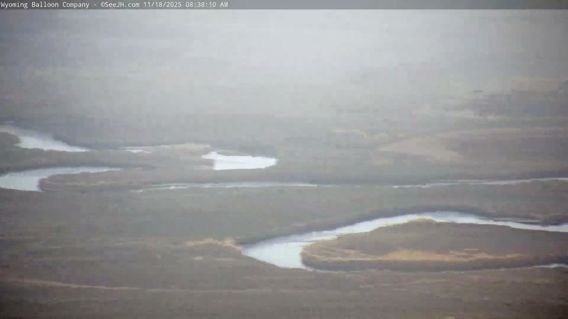 A dark, nighttime image shows a mostly black field with a few tiny, faint lights.