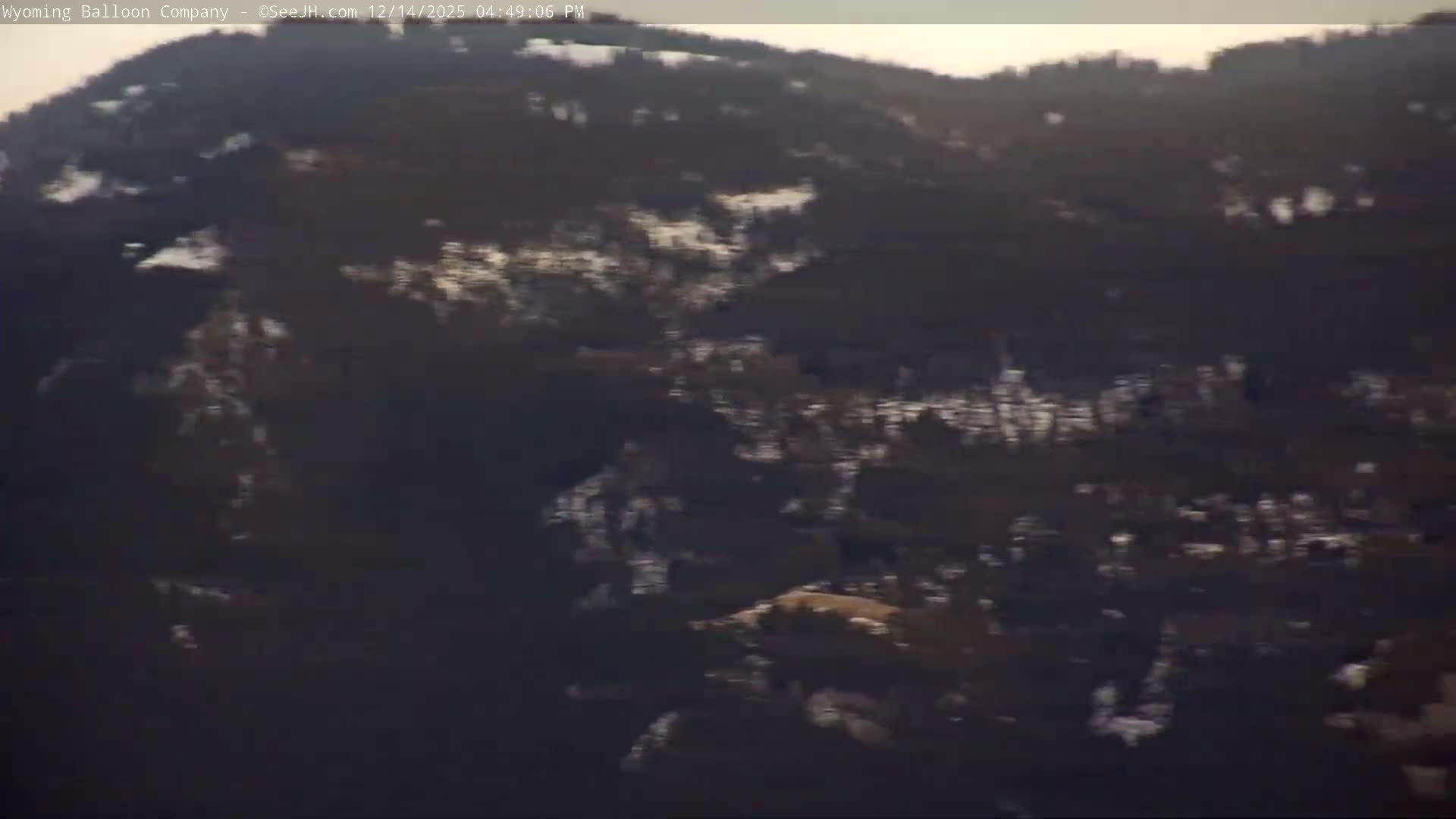 The image displays an extremely dark, almost black field with barely perceptible specks of color, indicating a pitch-black night with no visible features.