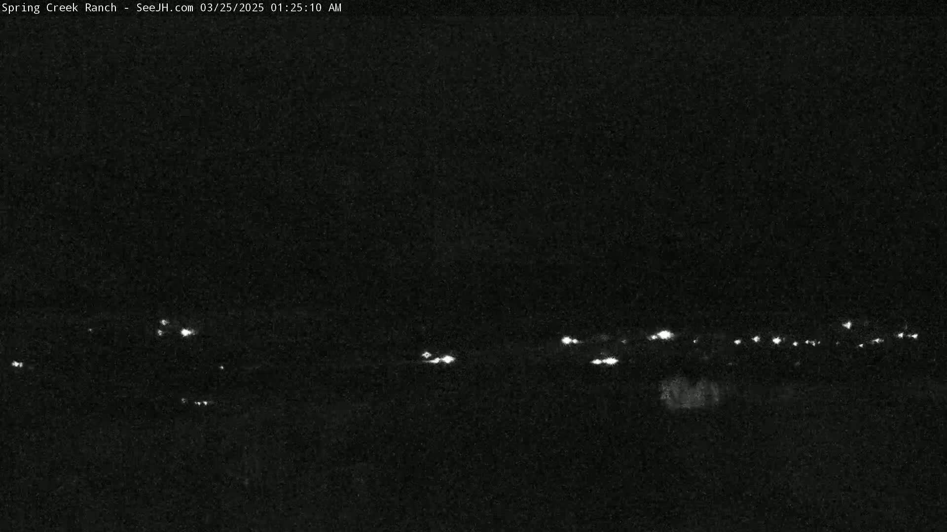 A nighttime, low-light image shows a line of distant lights in the far distance.