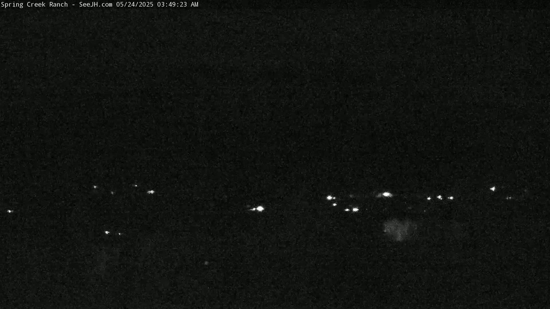 A nighttime long shot shows a line of distant lights in the dark.