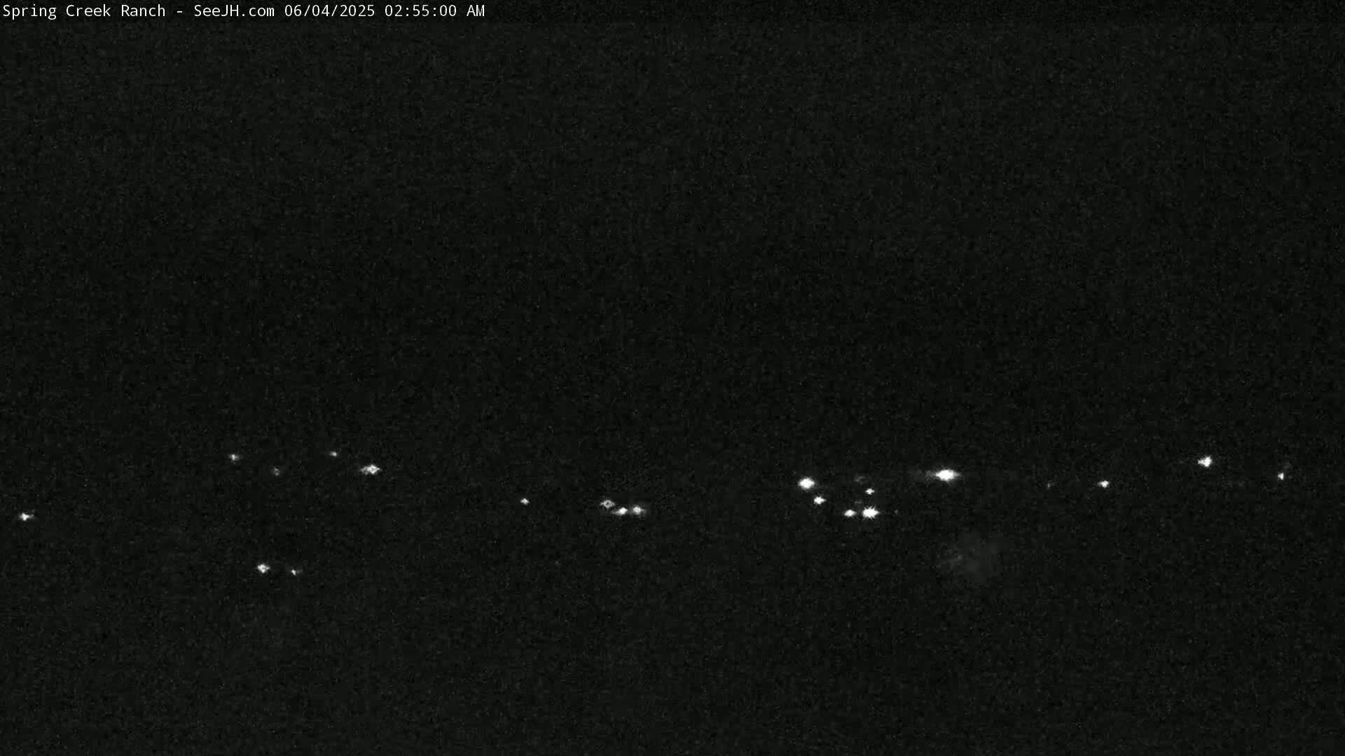 A nighttime long shot shows a distant line of small, faint lights.
