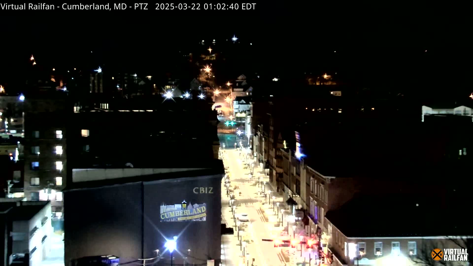 A nighttime, high-angle view of a city street illuminated by streetlights and building lights.