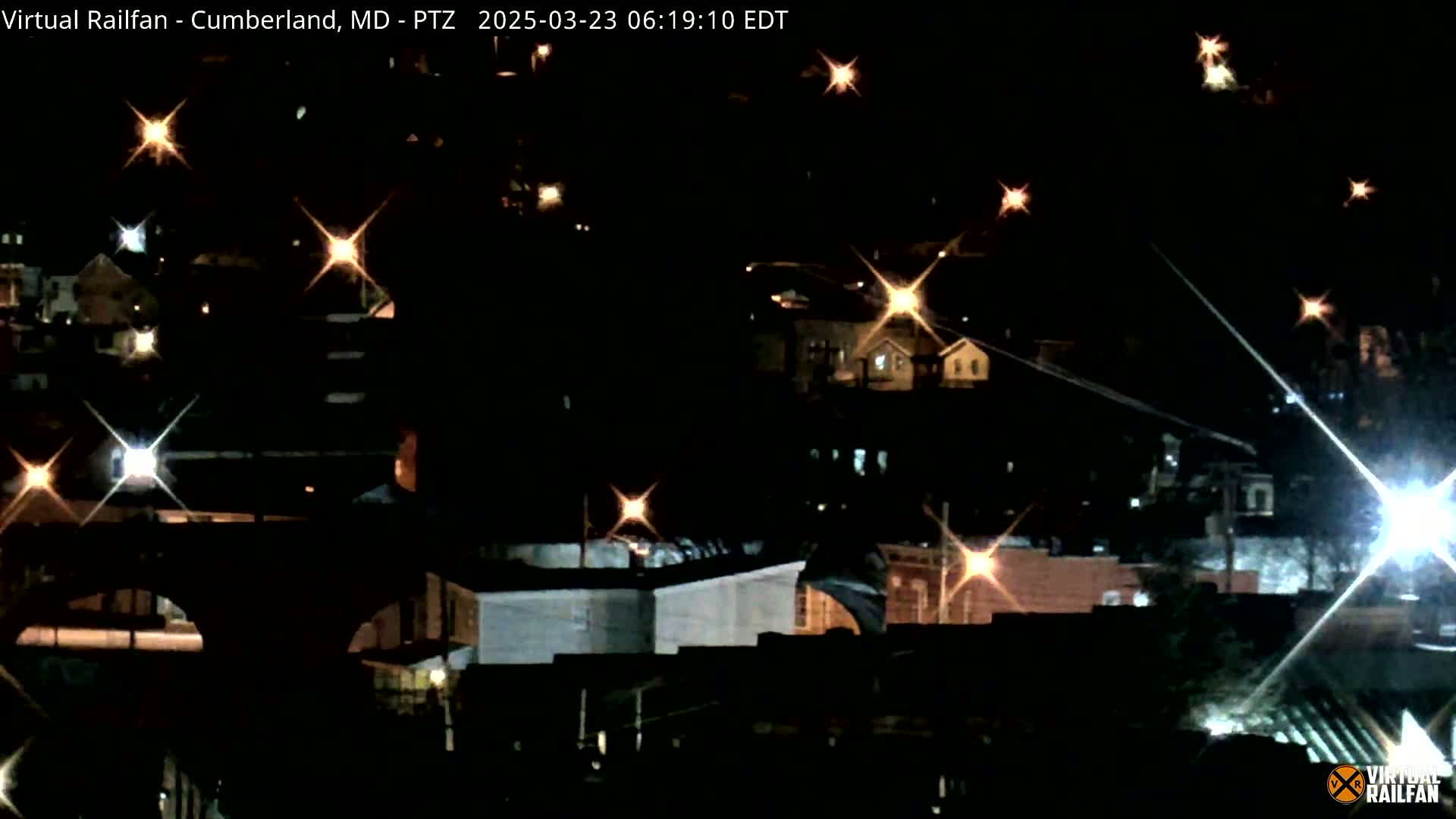 A nighttime view of a town with scattered lights illuminating buildings and streets.