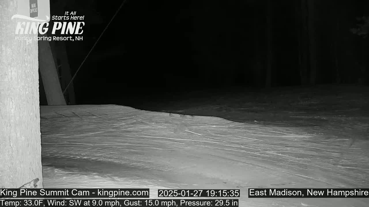A nighttime, snow-covered slope with a southwest wind at 9 mph and gusts up to 15 mph is visible next to a dark wooded area.