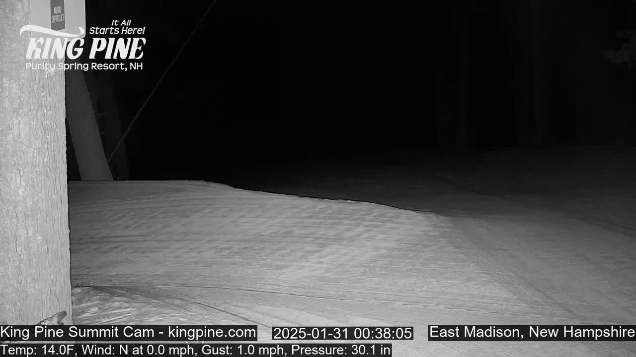 A snow-covered slope is visible at night under a dark sky.