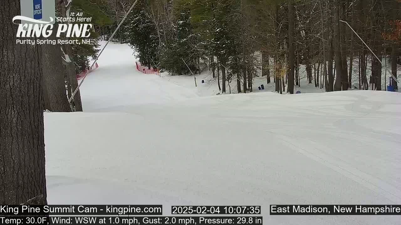A snow-covered ski slope winds through a wooded area on a 30°F day with a light west-southwest wind.