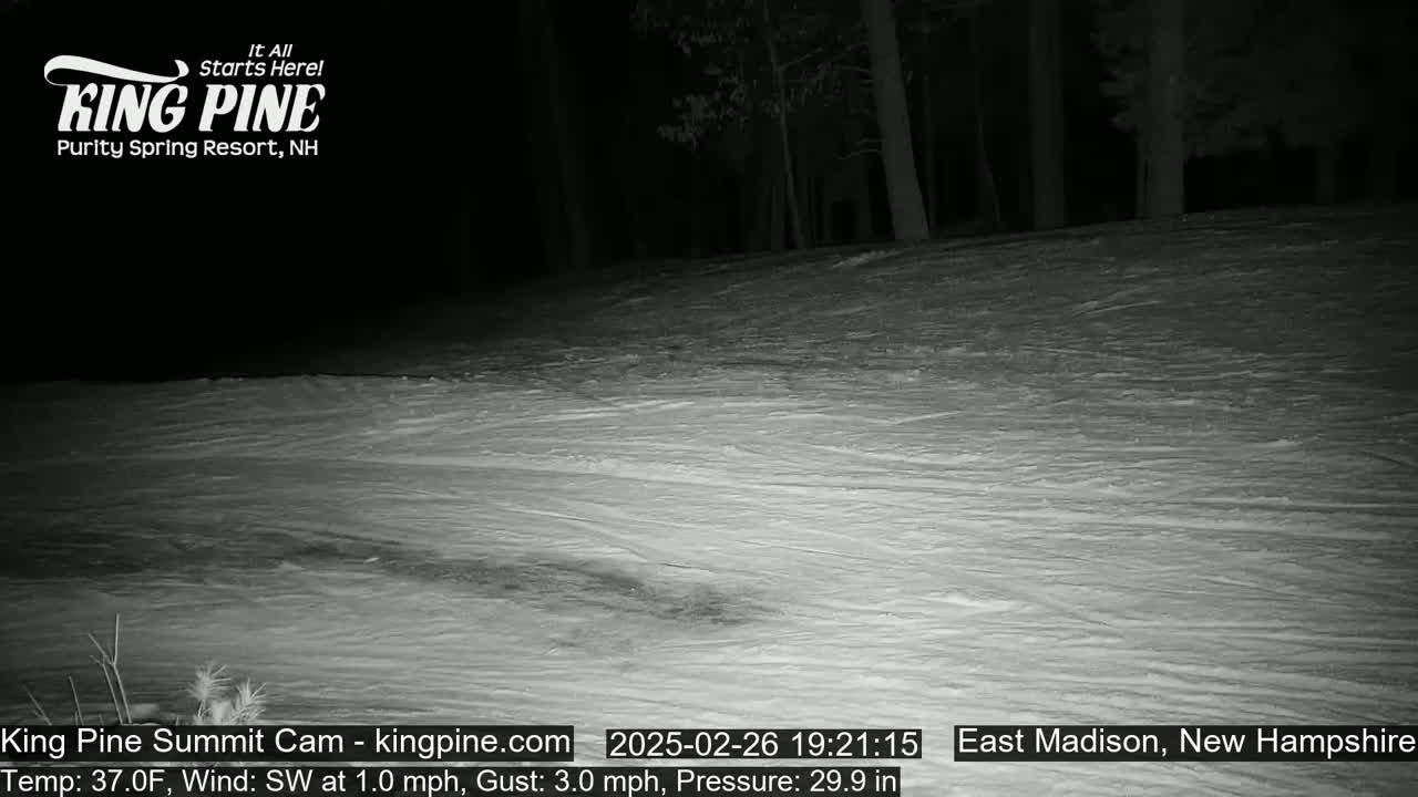 A nighttime view of a snow-covered slope under a dark sky with a slight southwest wind.