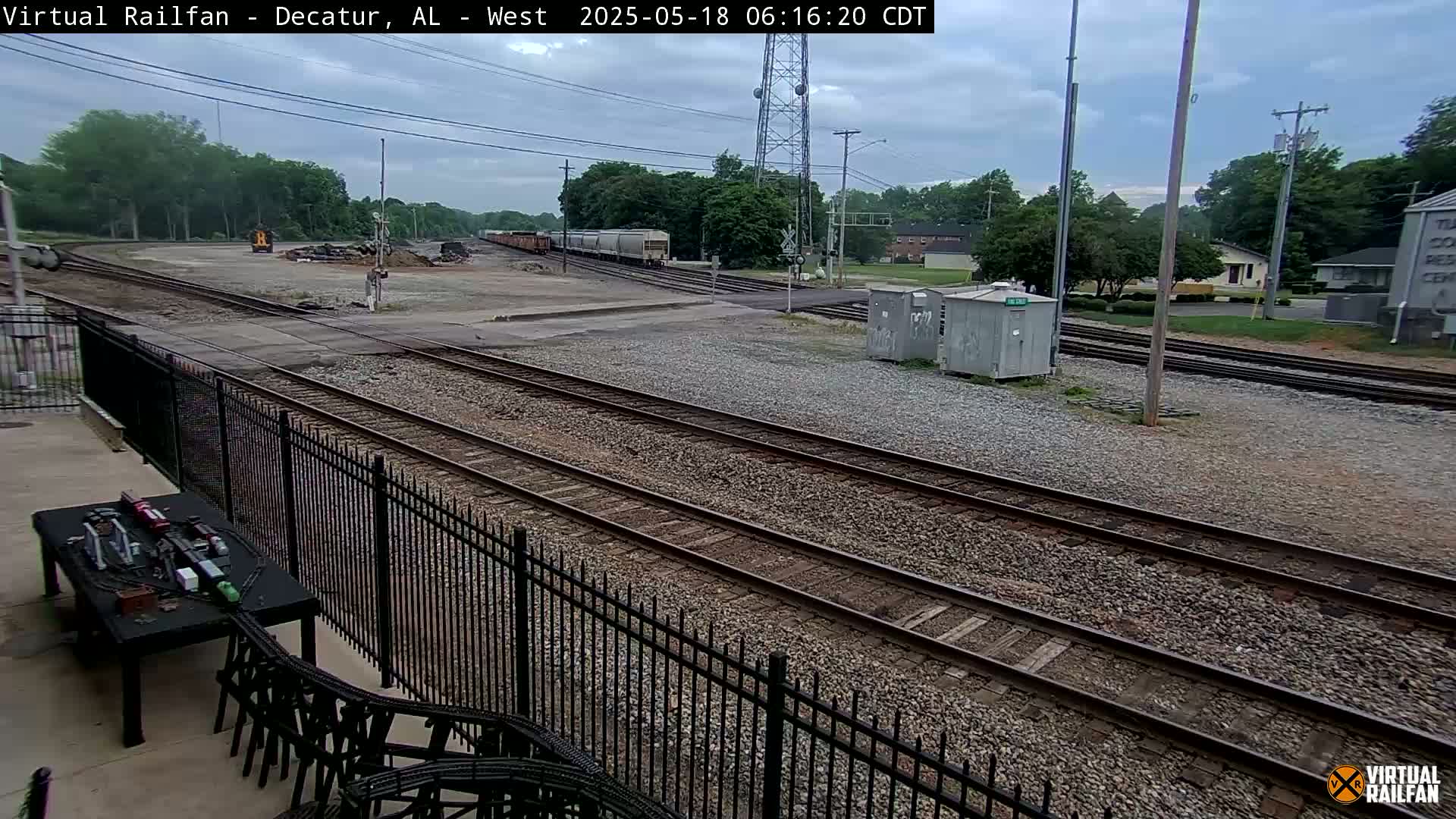 A train yard with multiple sets of tracks under an overcast sky.