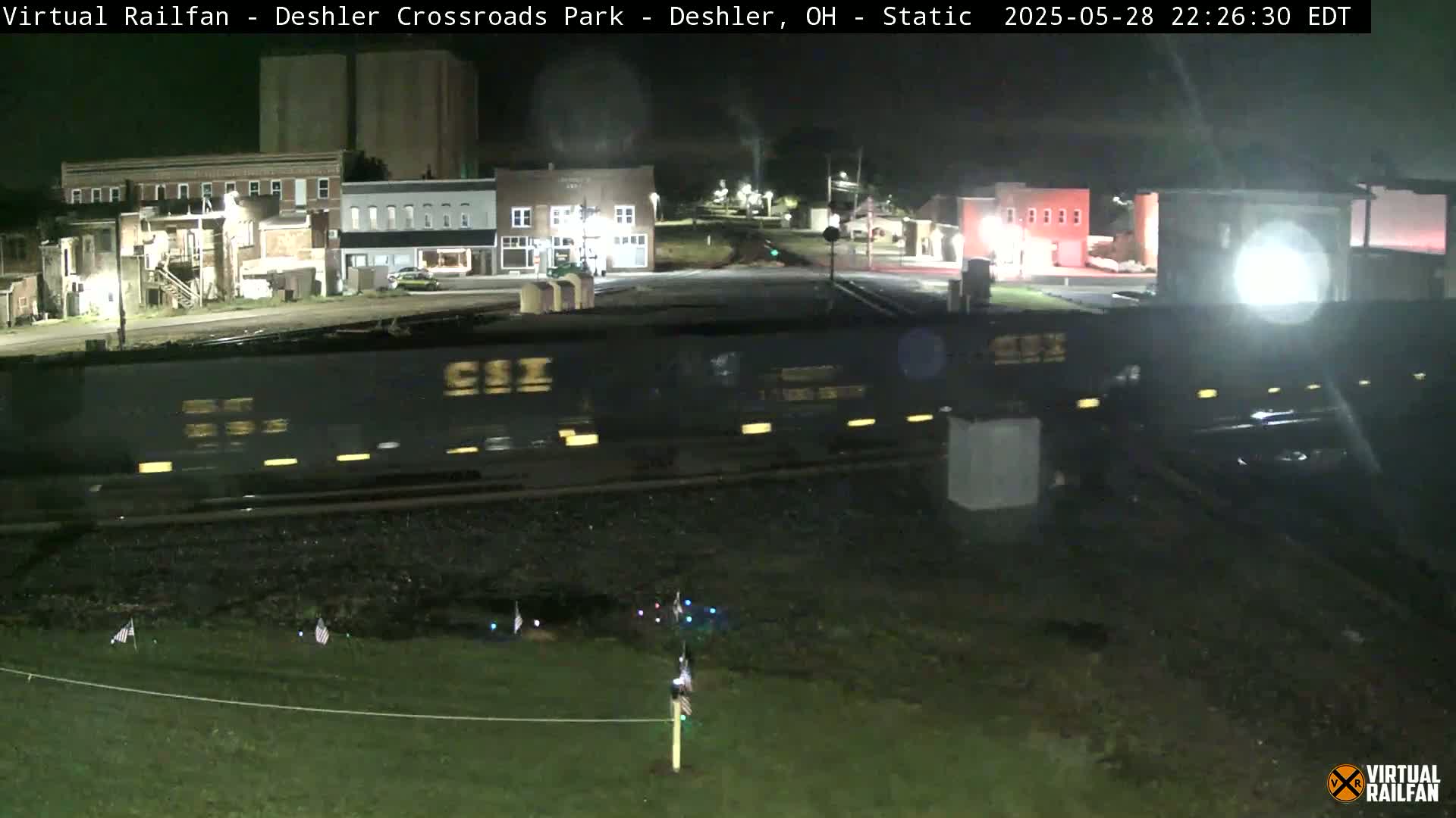 A long freight train passes by a small town at night.