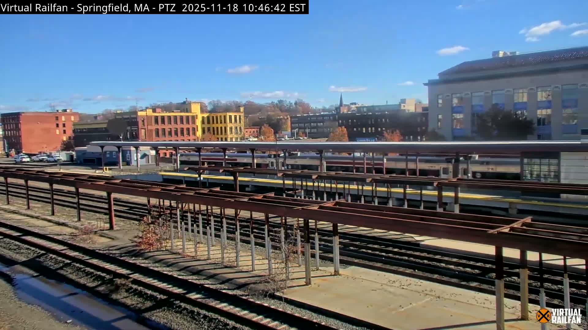 A nighttime view of a train station with several passenger trains at the platform under a clear sky.