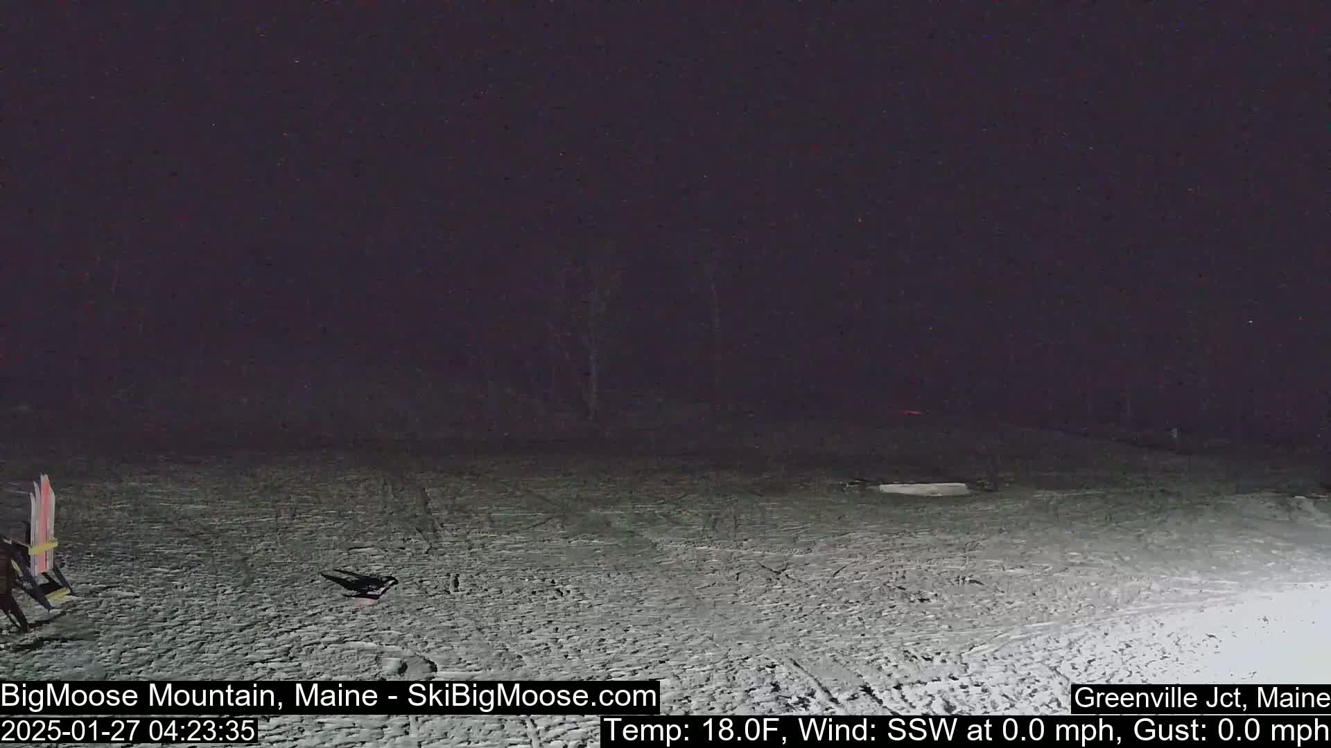 A snow-covered area is visible at night under a dark sky, with a calm wind and a temperature of 18°F.