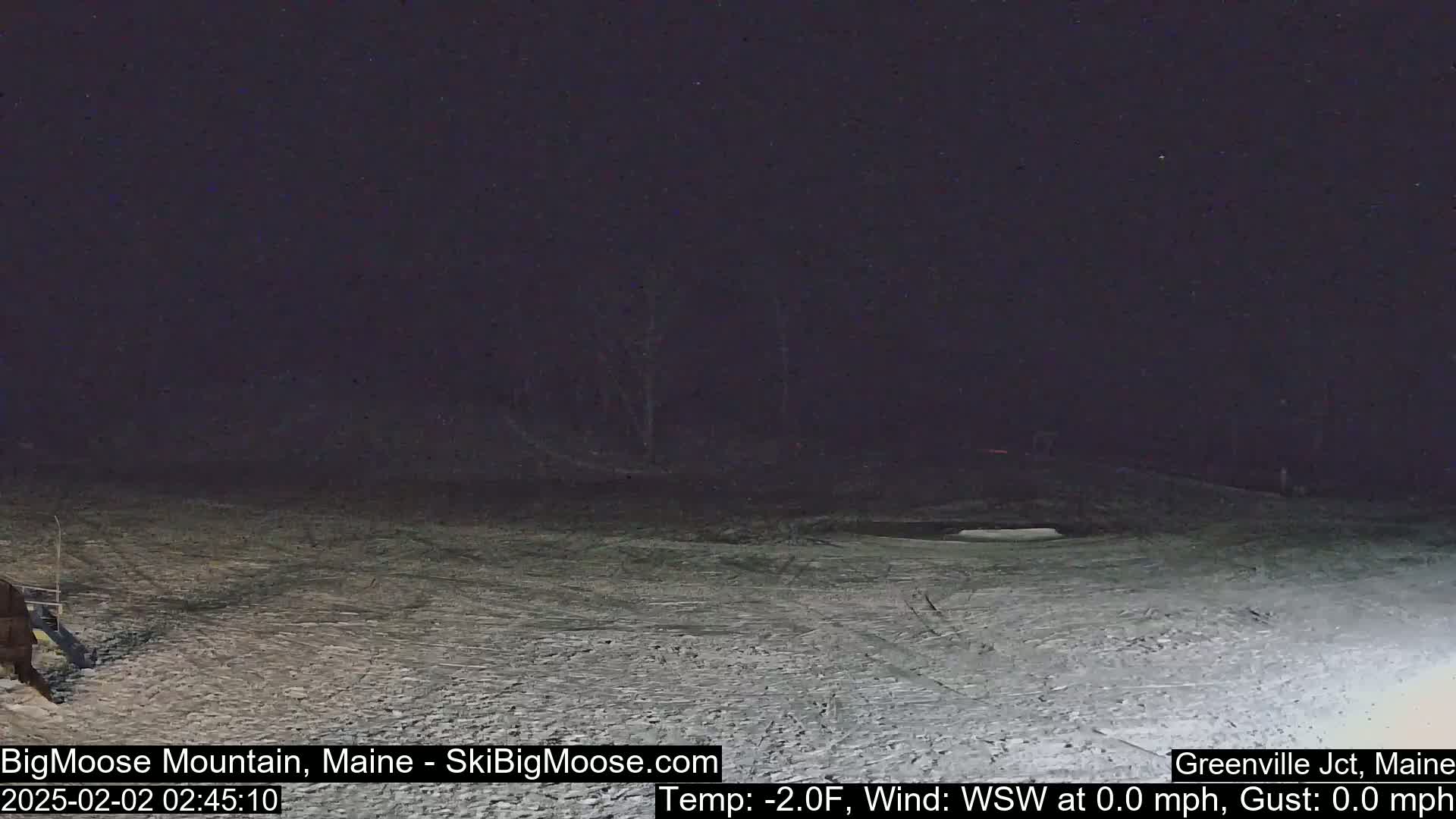 A snow-covered, dark area is visible at night under a clear sky.