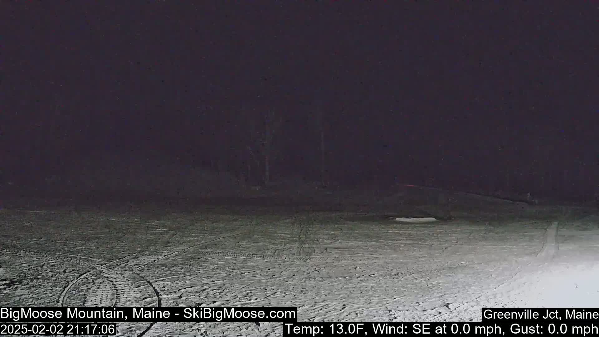 A snow-covered, dark area at night with a calm, 13°F temperature.