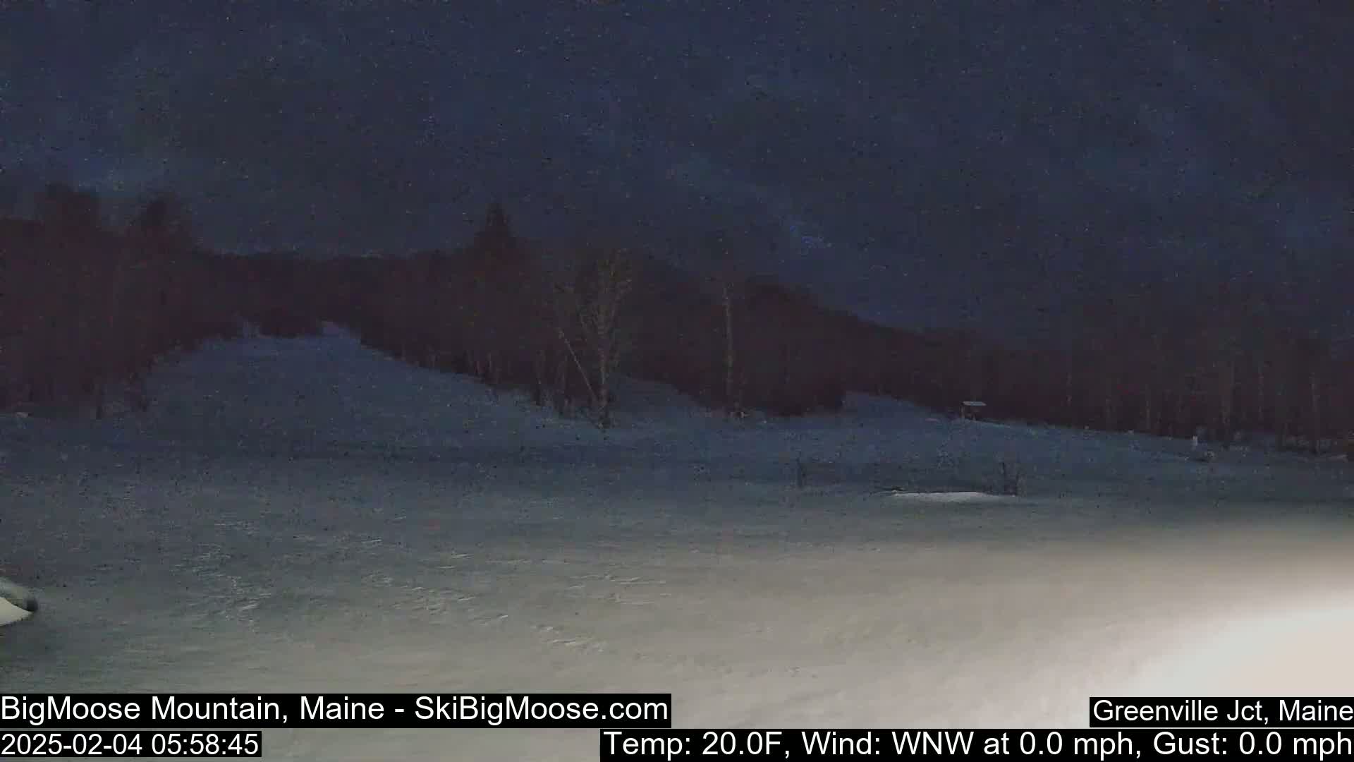 A snow-covered landscape at night under a dark sky, with a calm wind and a temperature of 20 degrees Fahrenheit.