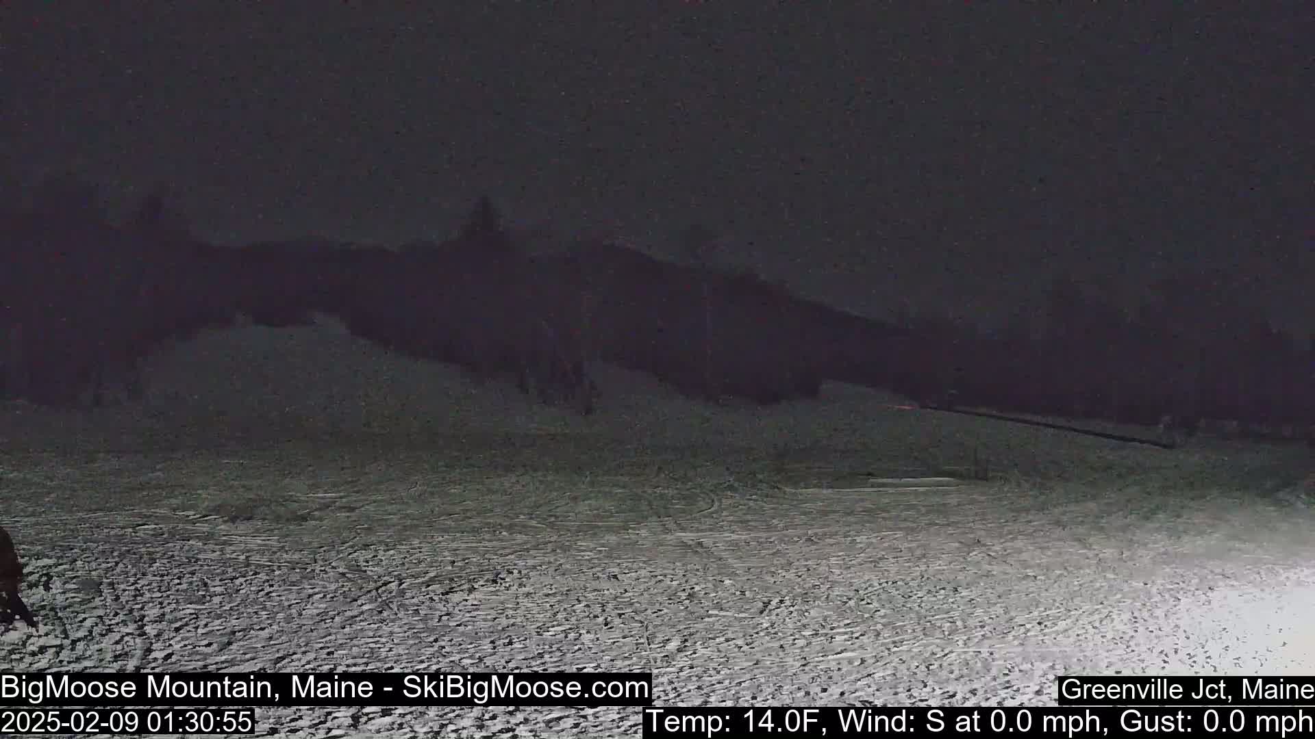 A snow-covered landscape is visible at night under dark skies.