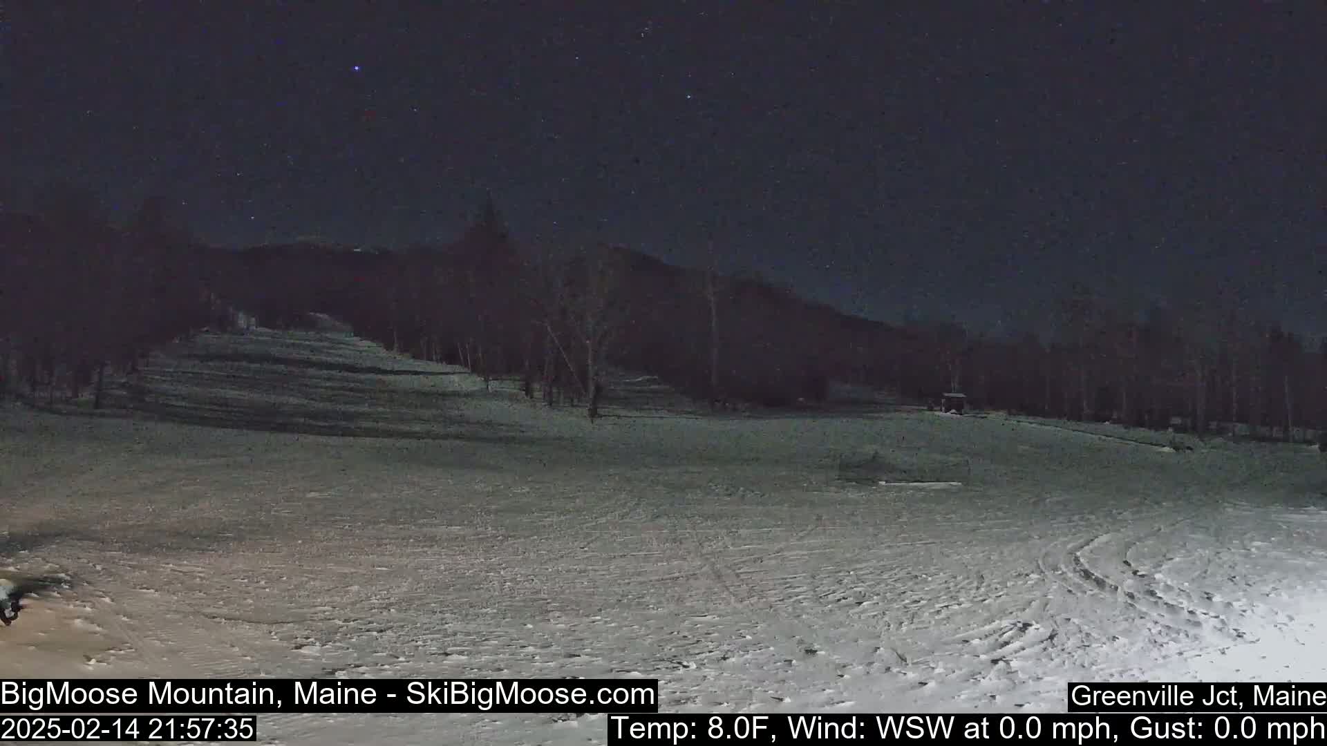 A snow-covered ski slope at night under a starry sky, with calm, cold weather.